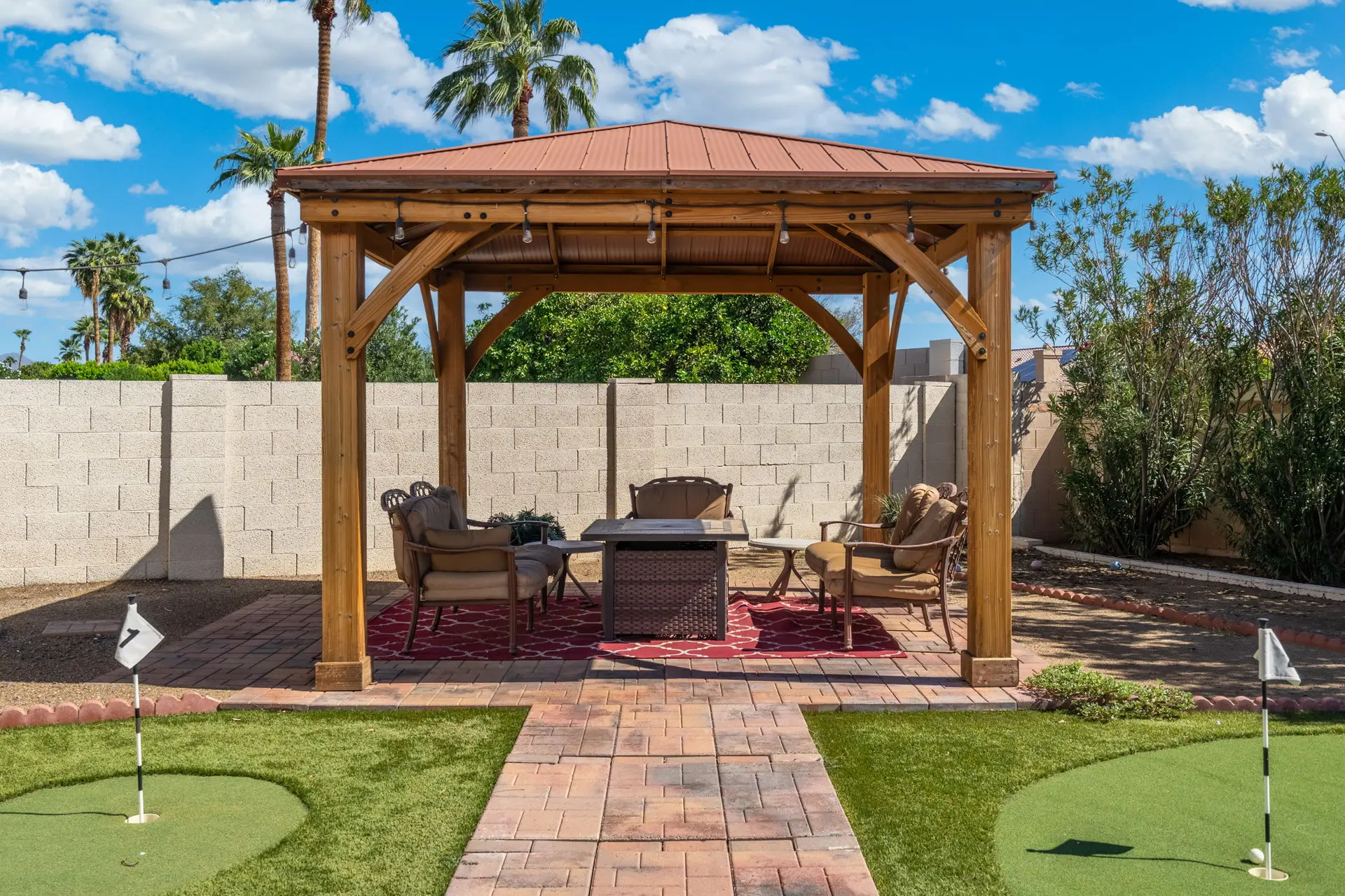 Outdoor patio with gazebo, fire pit, seating, and a mini-golf course.