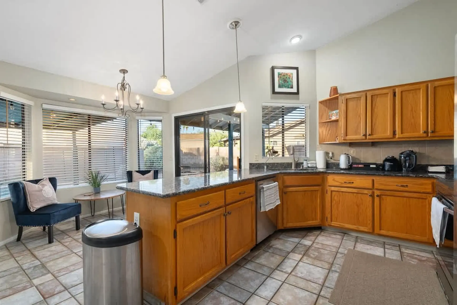Kitchen with wooden cabinets, granite countertops, and a tile floor.