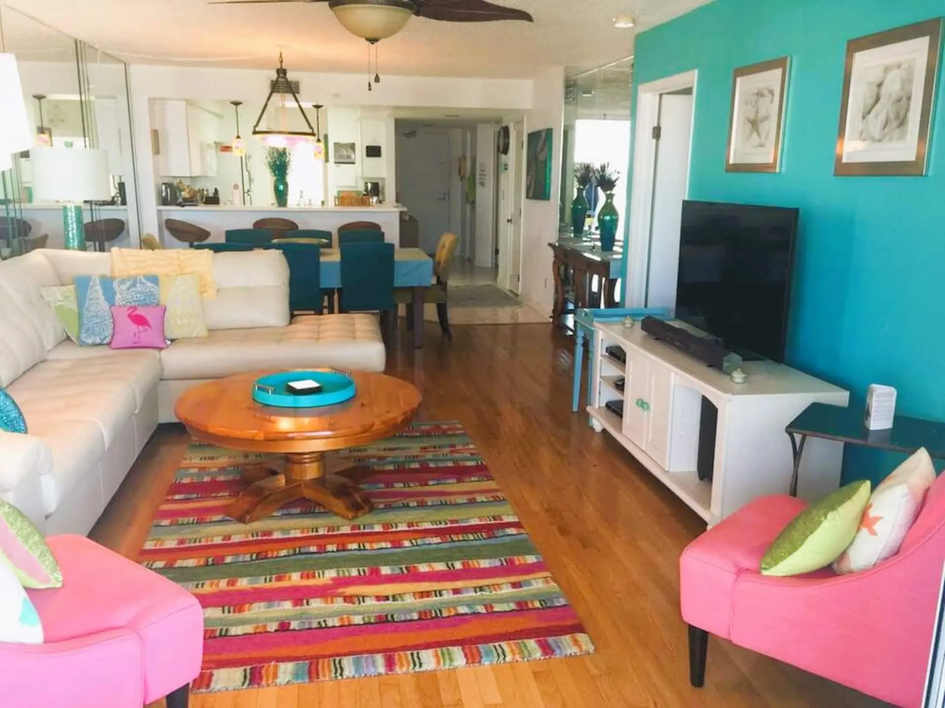 A living room with a sectional couch, coffee table, rug, and TV.
