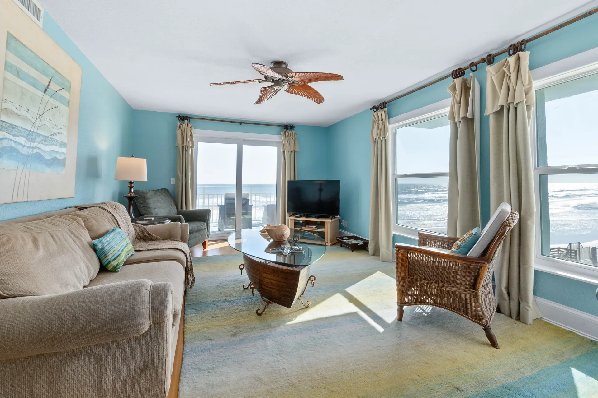 A living room with blue walls, a couch, a coffee table, and a TV.