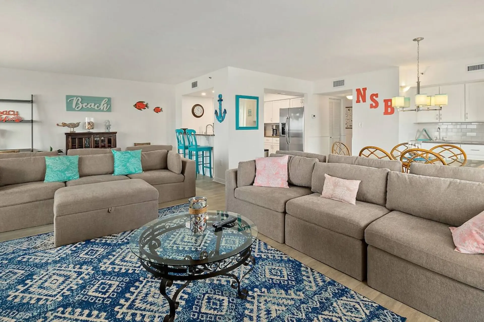 A living room with a sectional sofa, coffee table, and blue patterned rug.