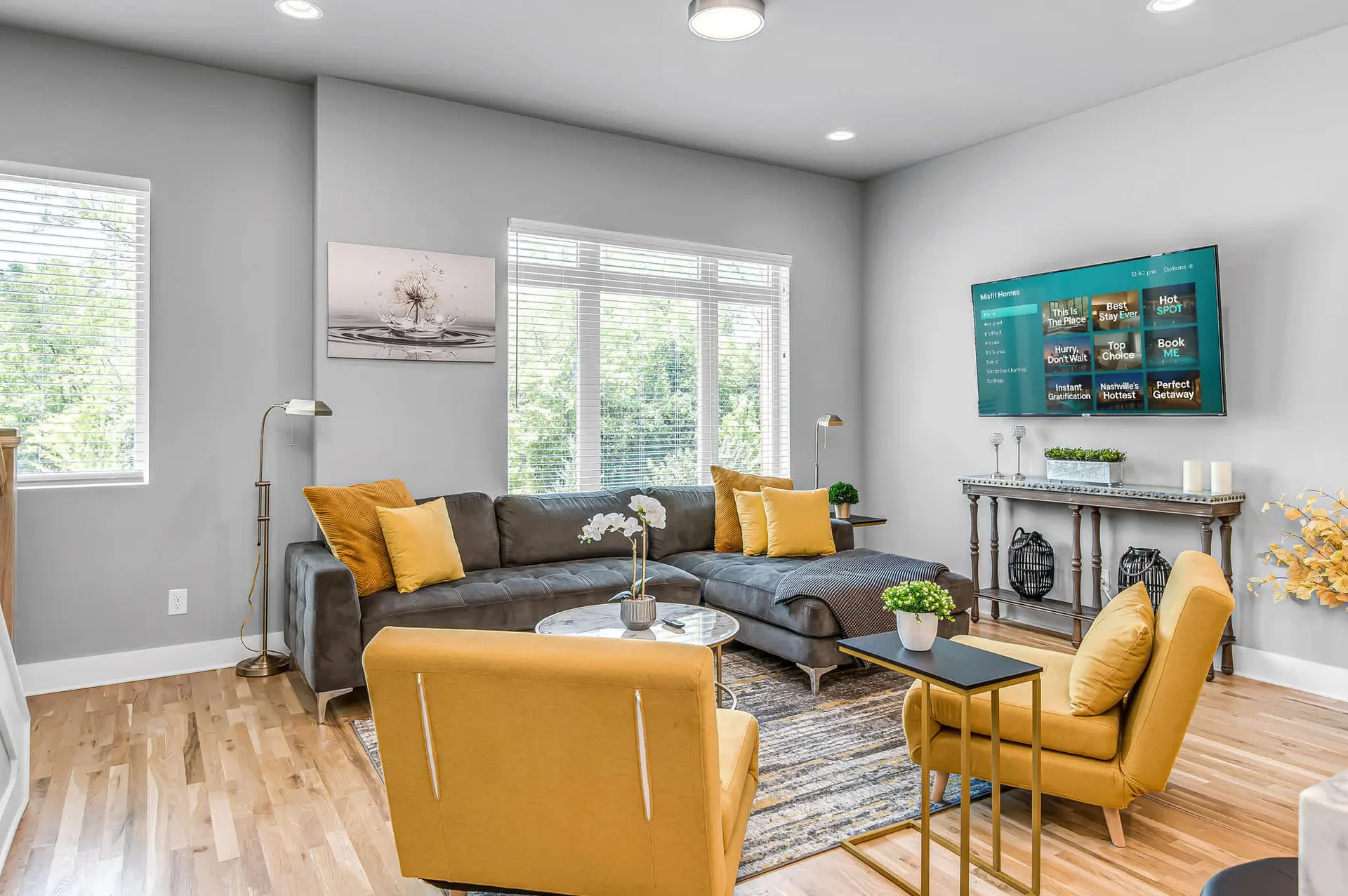 Living room with a sectional sofa, accent chairs, and a wall-mounted TV.