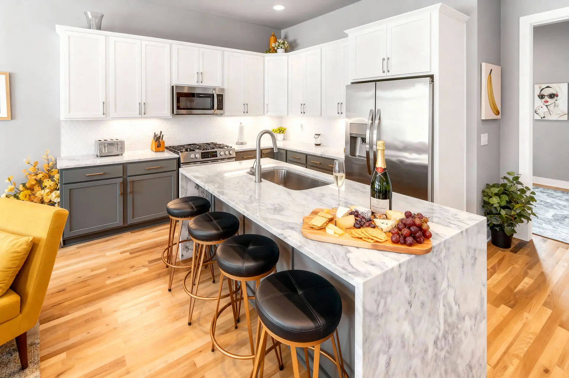 Modern kitchen with white cabinets, a marble island, and bar stools.