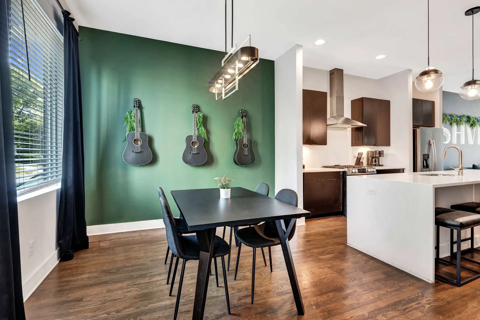 A dining room with guitars on the wall and a kitchen island.