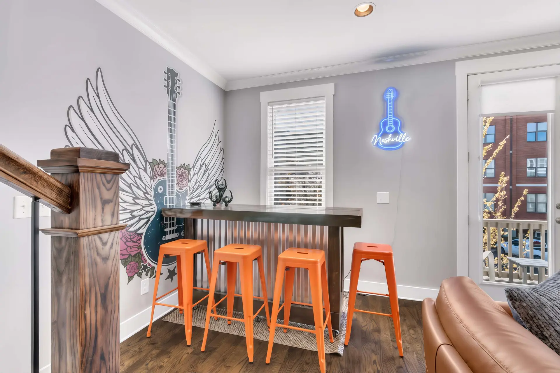 A bar area with orange stools and a guitar mural on the wall.
