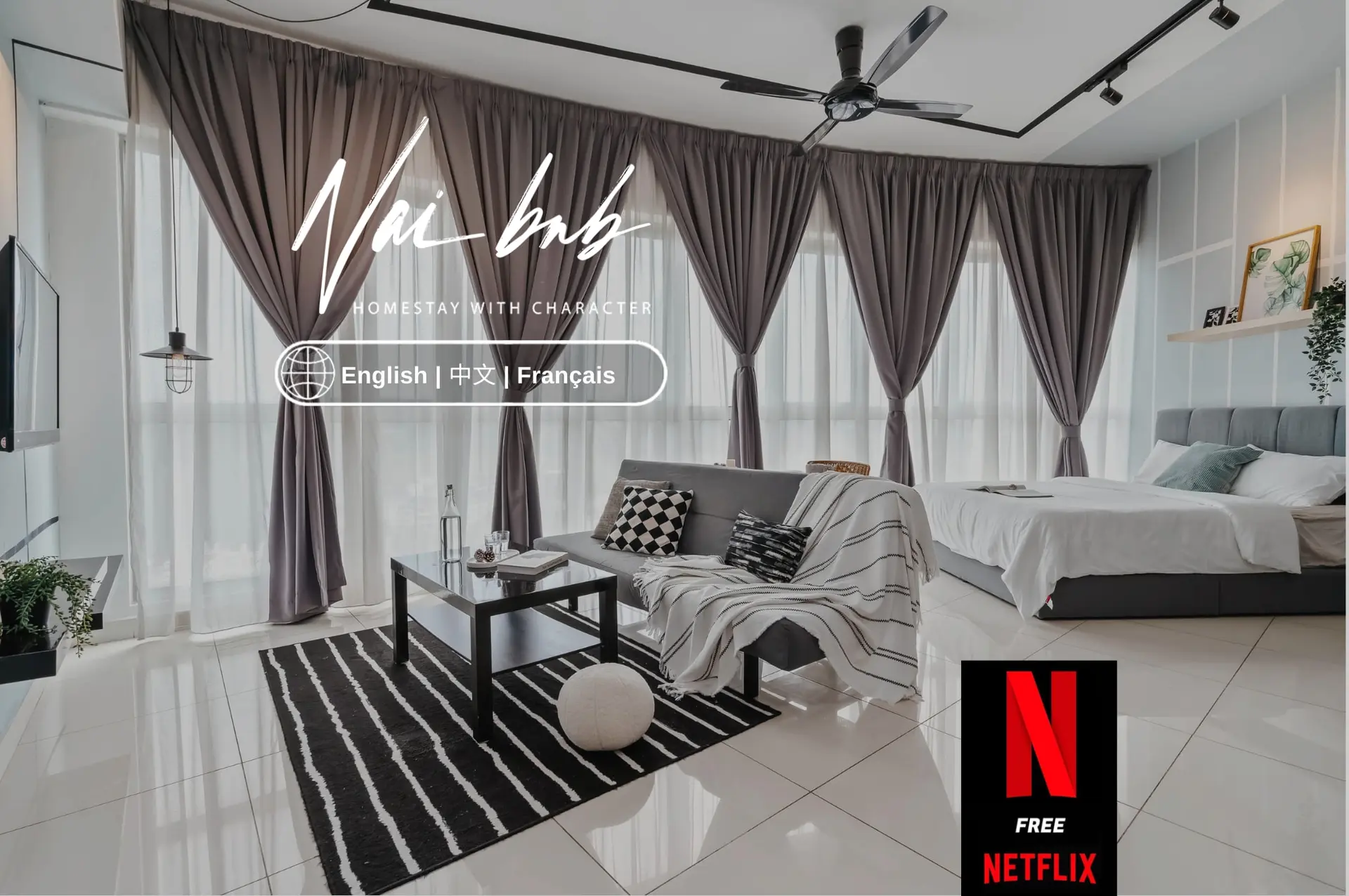 A bedroom and living room with a bed, sofa, coffee table, and Netflix logo.