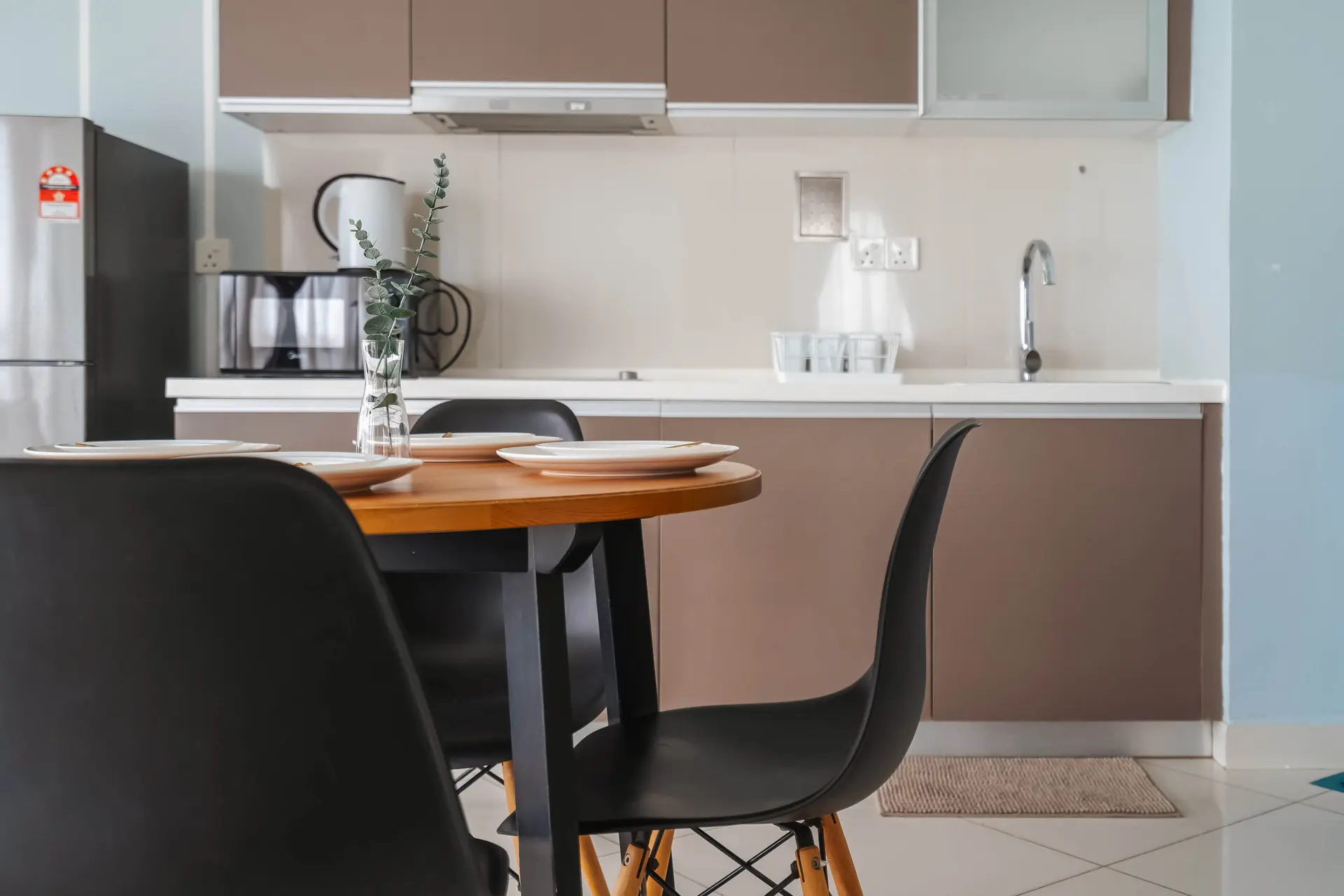 A modern kitchen with a dining set and appliances.