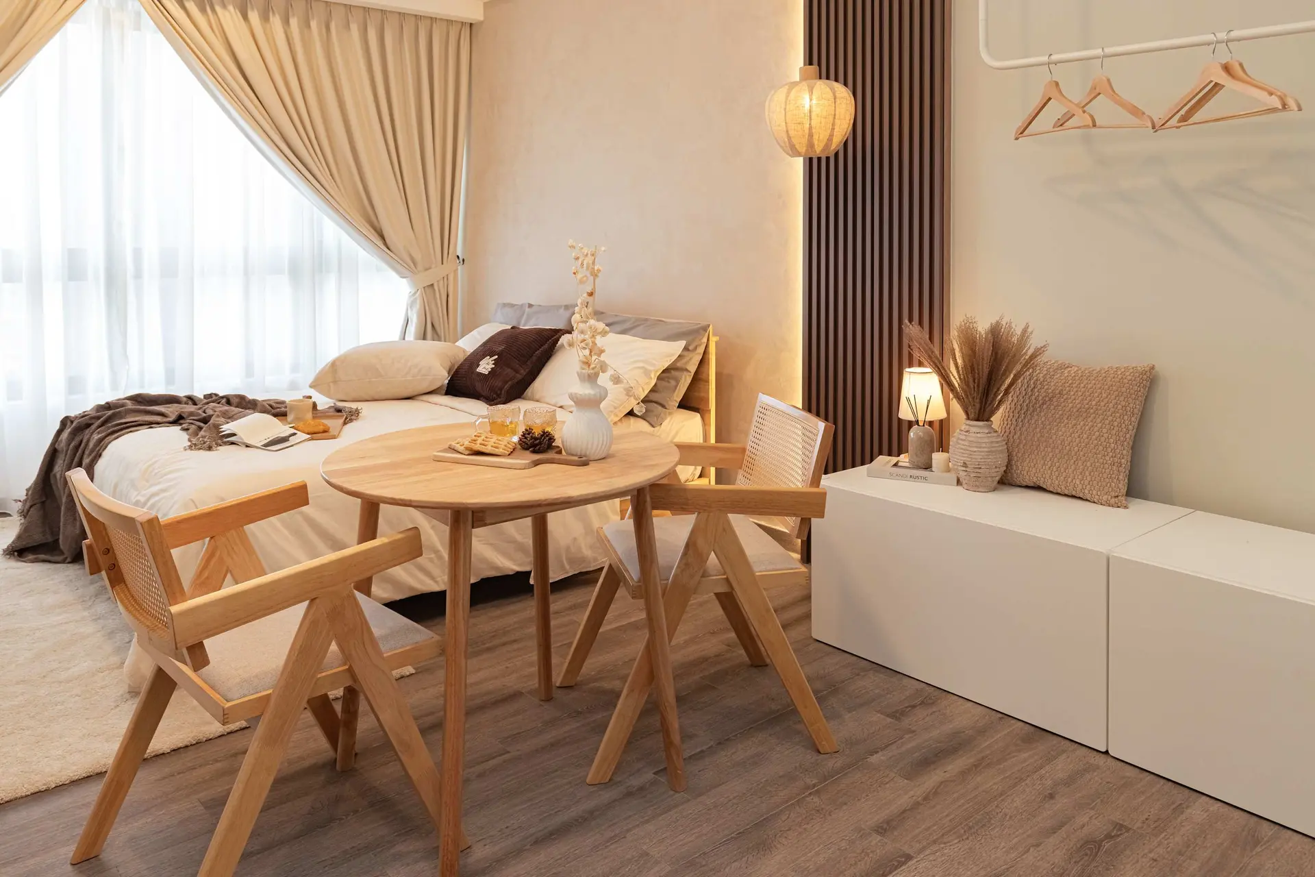 A bedroom with a bed, dining table, and chairs in a modern style.