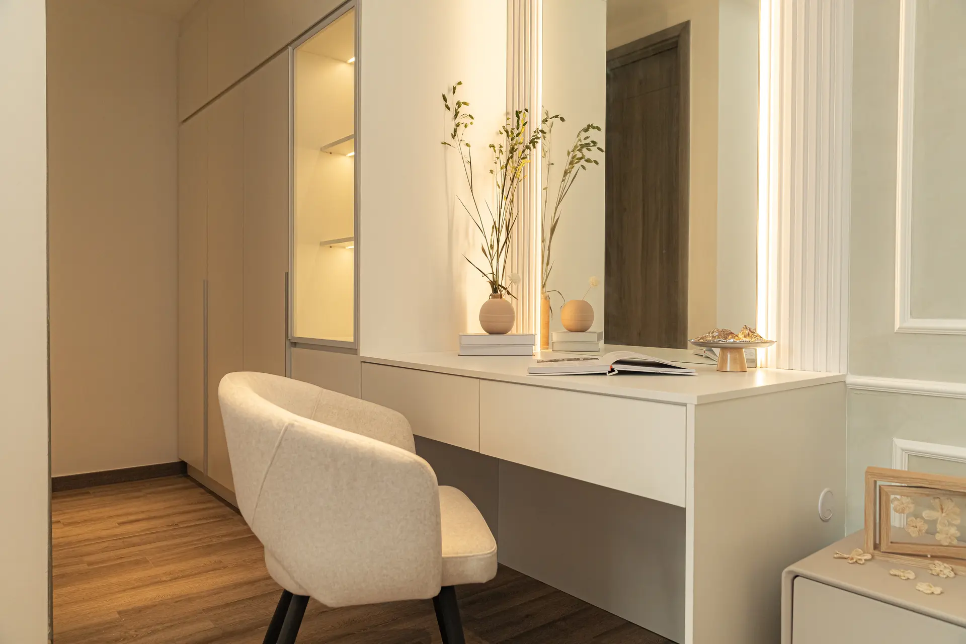 Interior scene of a bedroom with a vanity and chair.