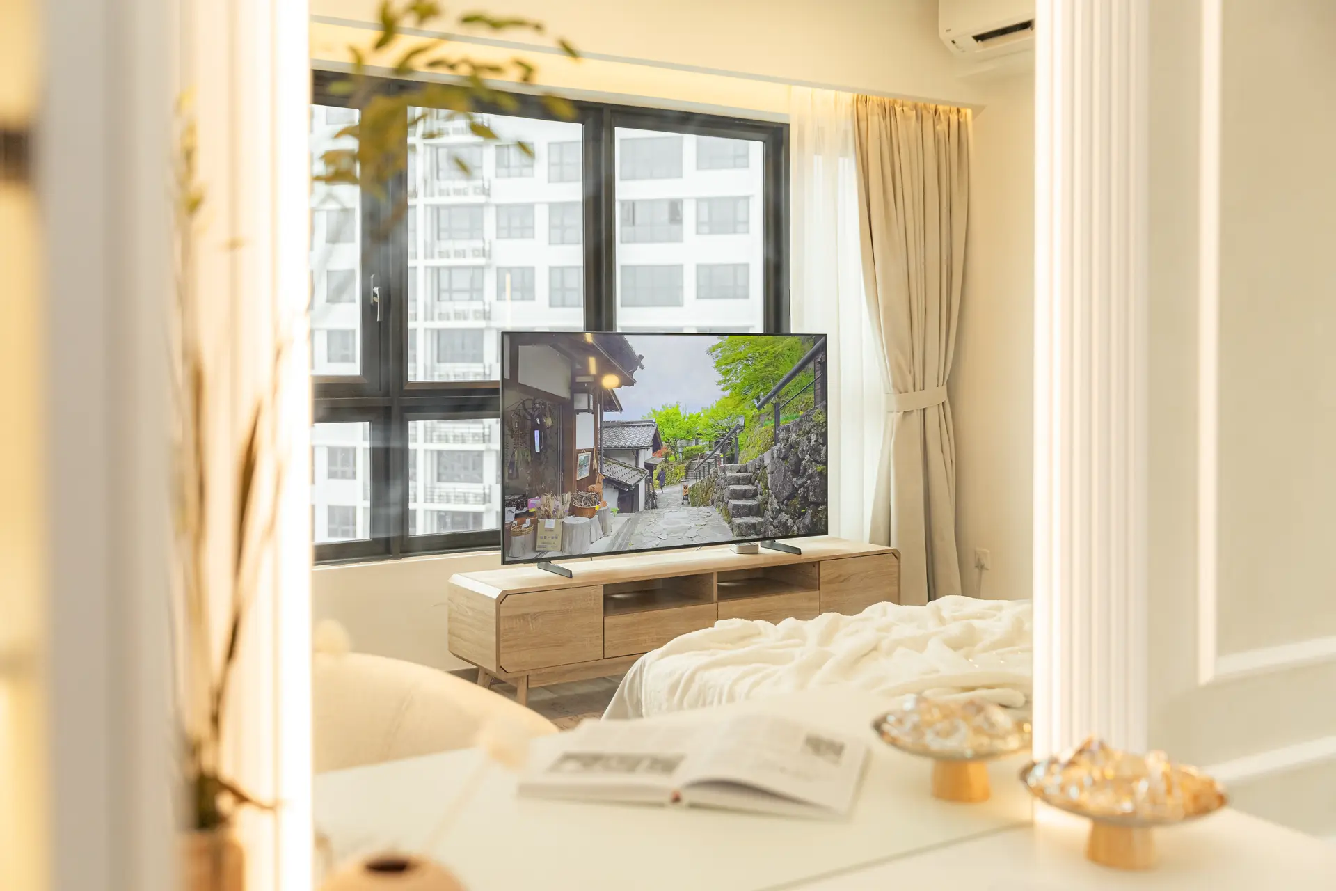A television screen displays a picturesque street scene.