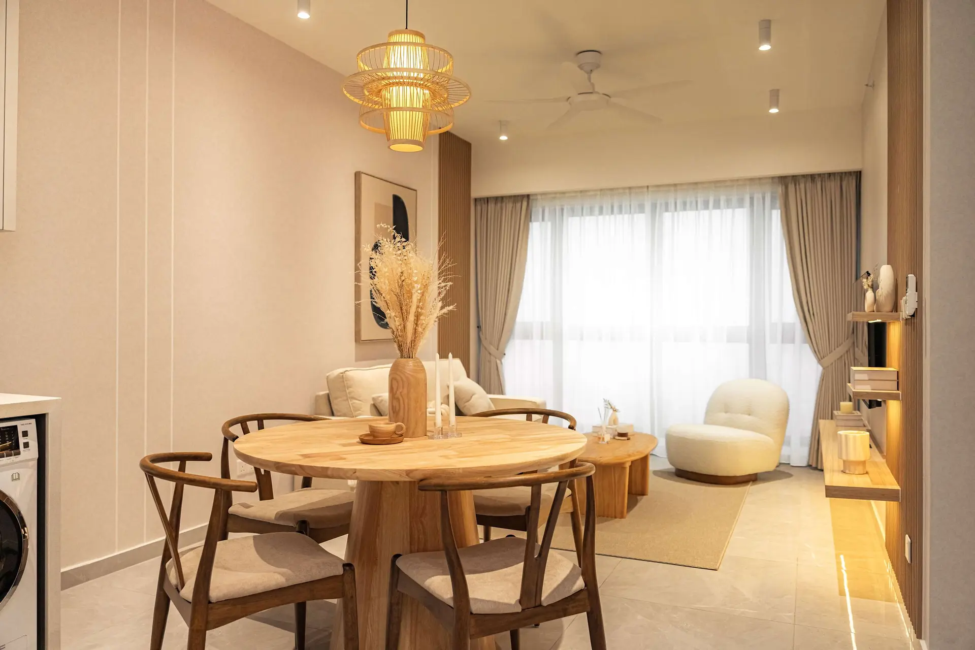 A modern dining and living room with a round wooden table and chairs.