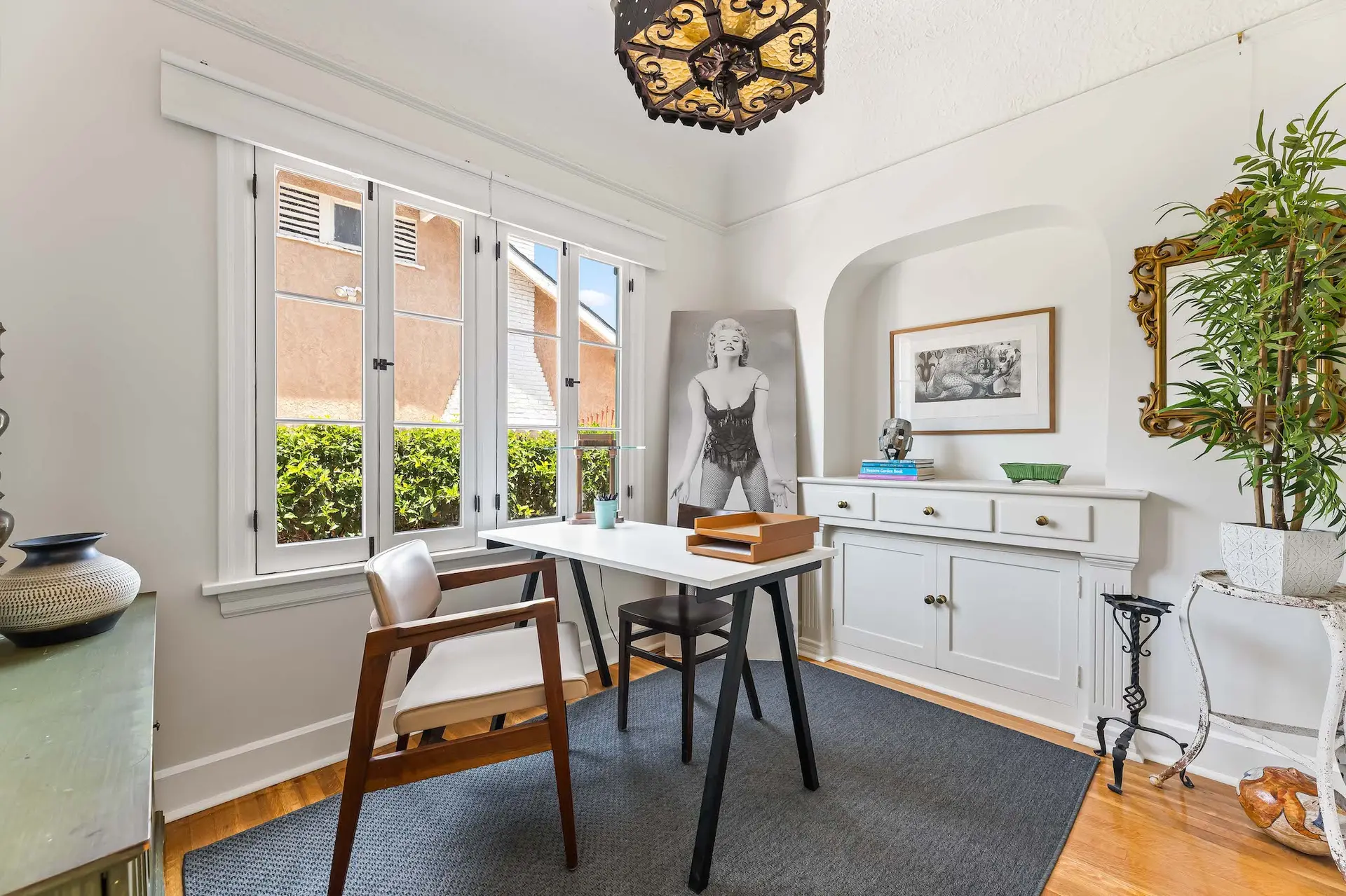 A modern office with a desk, chair, and a large Marilyn Monroe print.