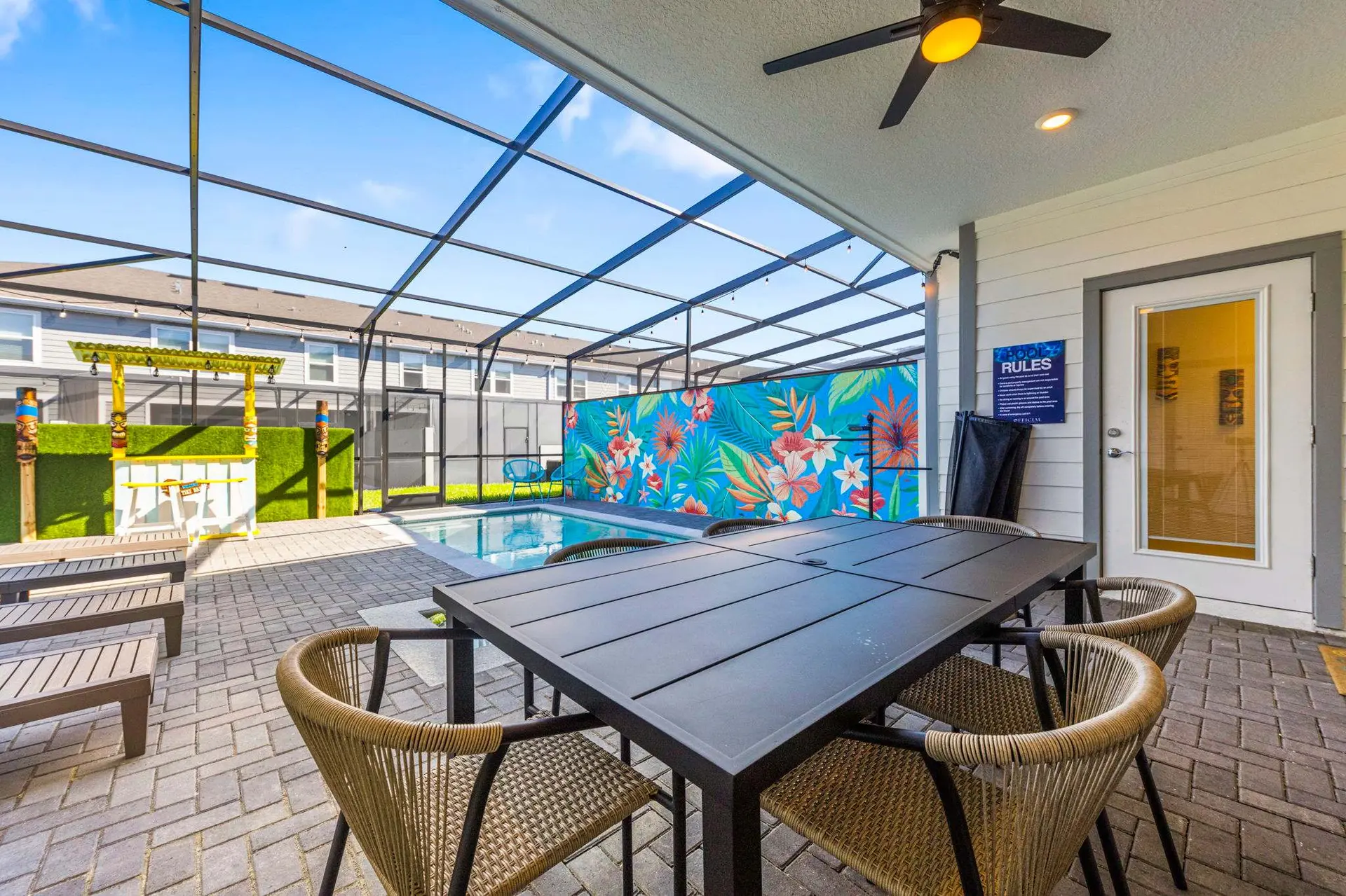 Outdoor pool patio with a dining table, chairs, and a bar.