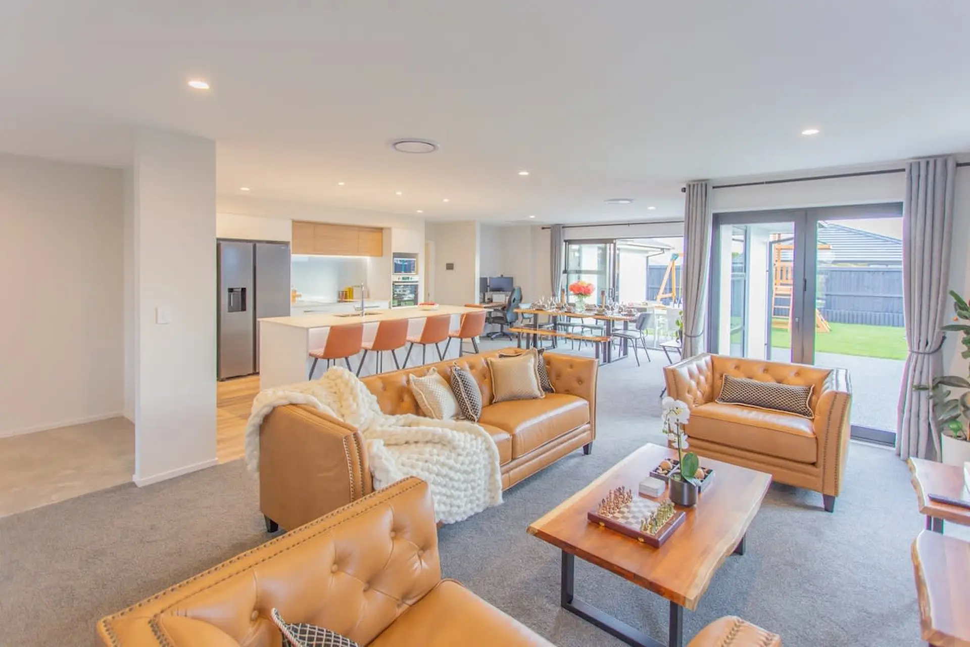 Nice living room with brown couches shown from one corner