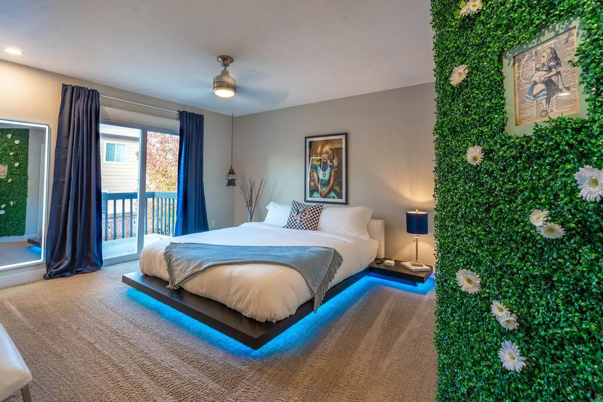 A bedroom with a bed, a green wall with flowers, and blue lights.