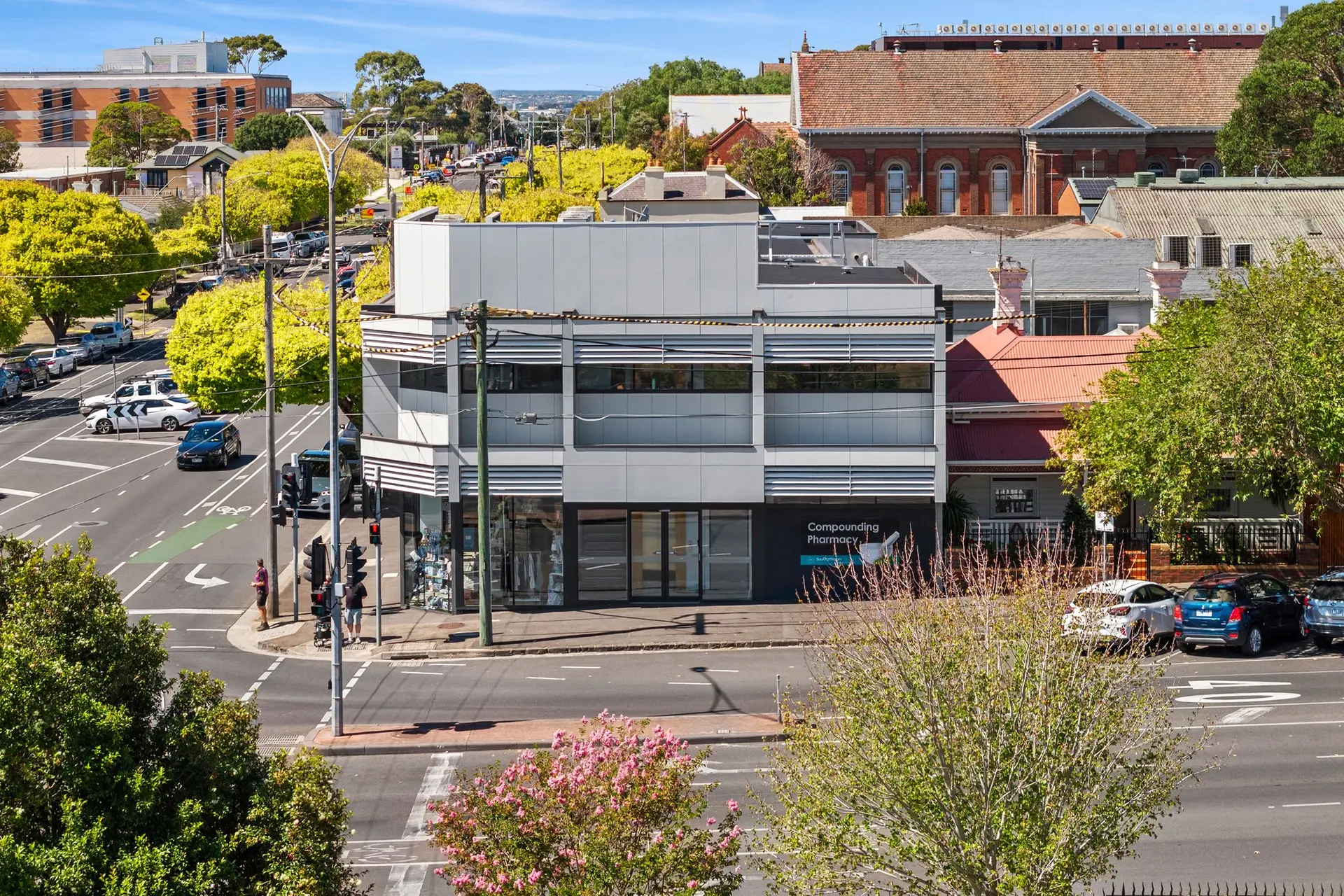 A modern pharmacy building with a sign that reads "Compounding Pharmacy".