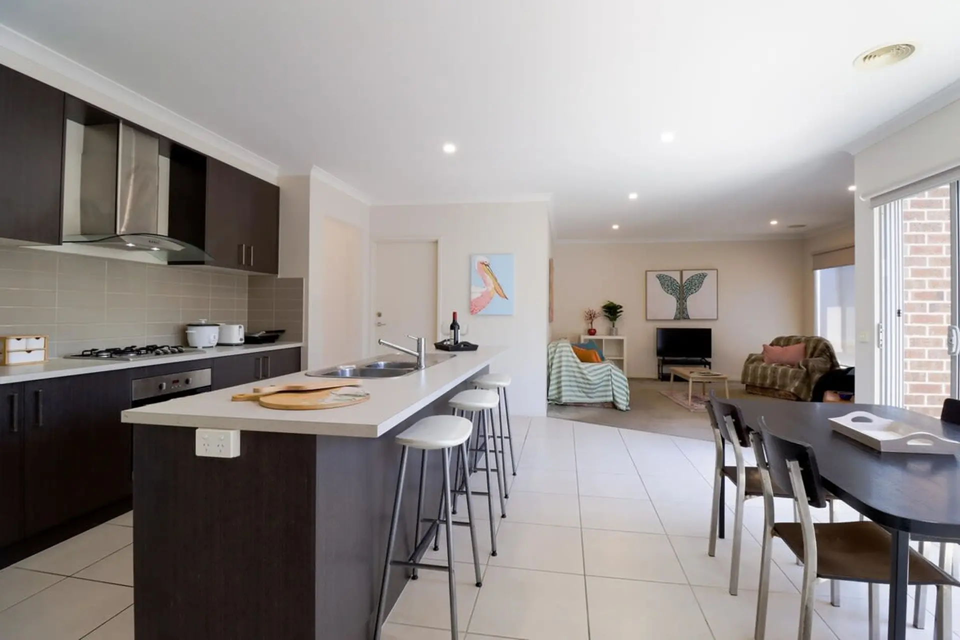A modern kitchen and dining area with a large island and a dining table.