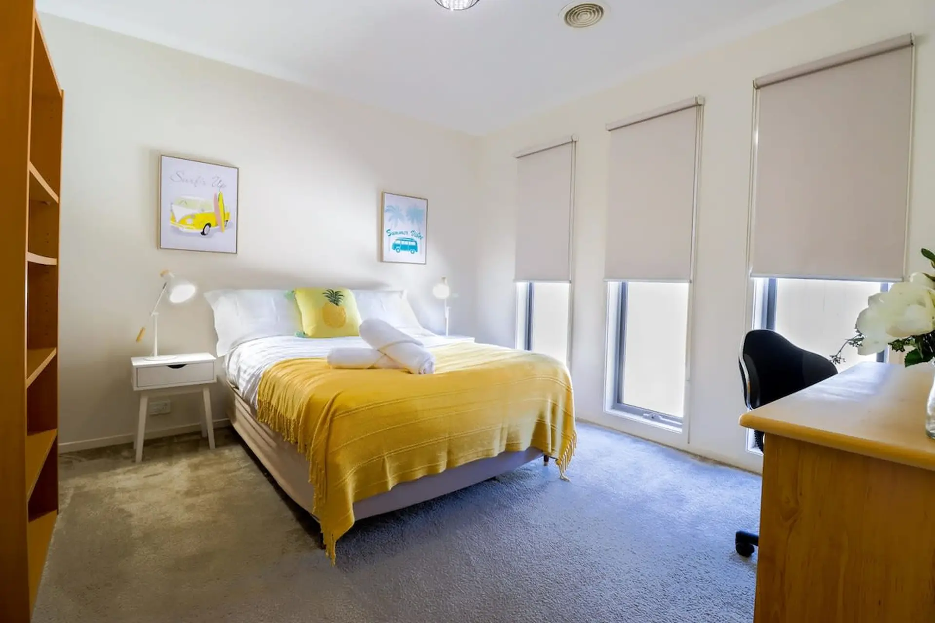 A bedroom with a bed, desk, and bookshelf.