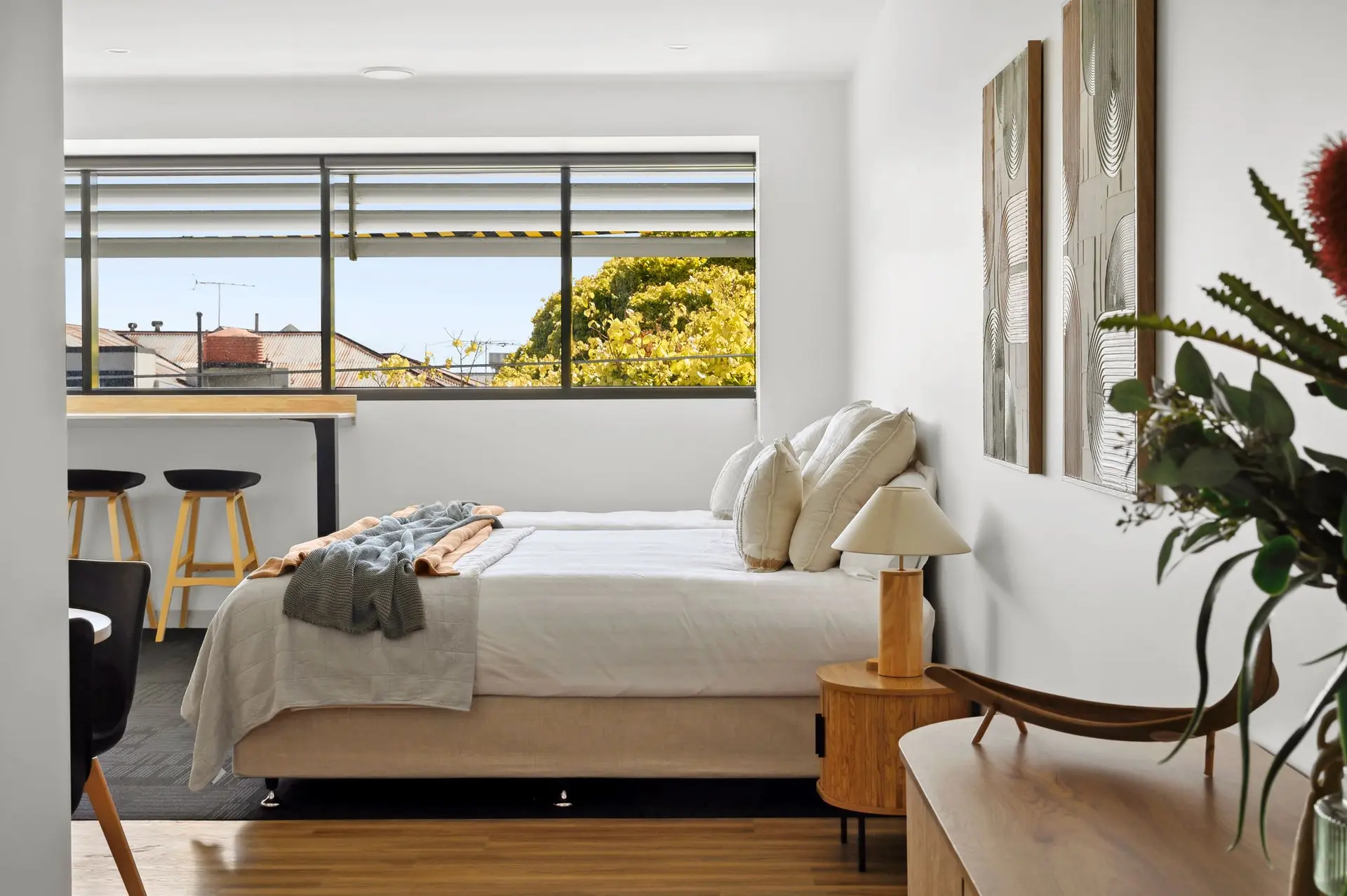 A bedroom with a bed, nightstand, and window view.