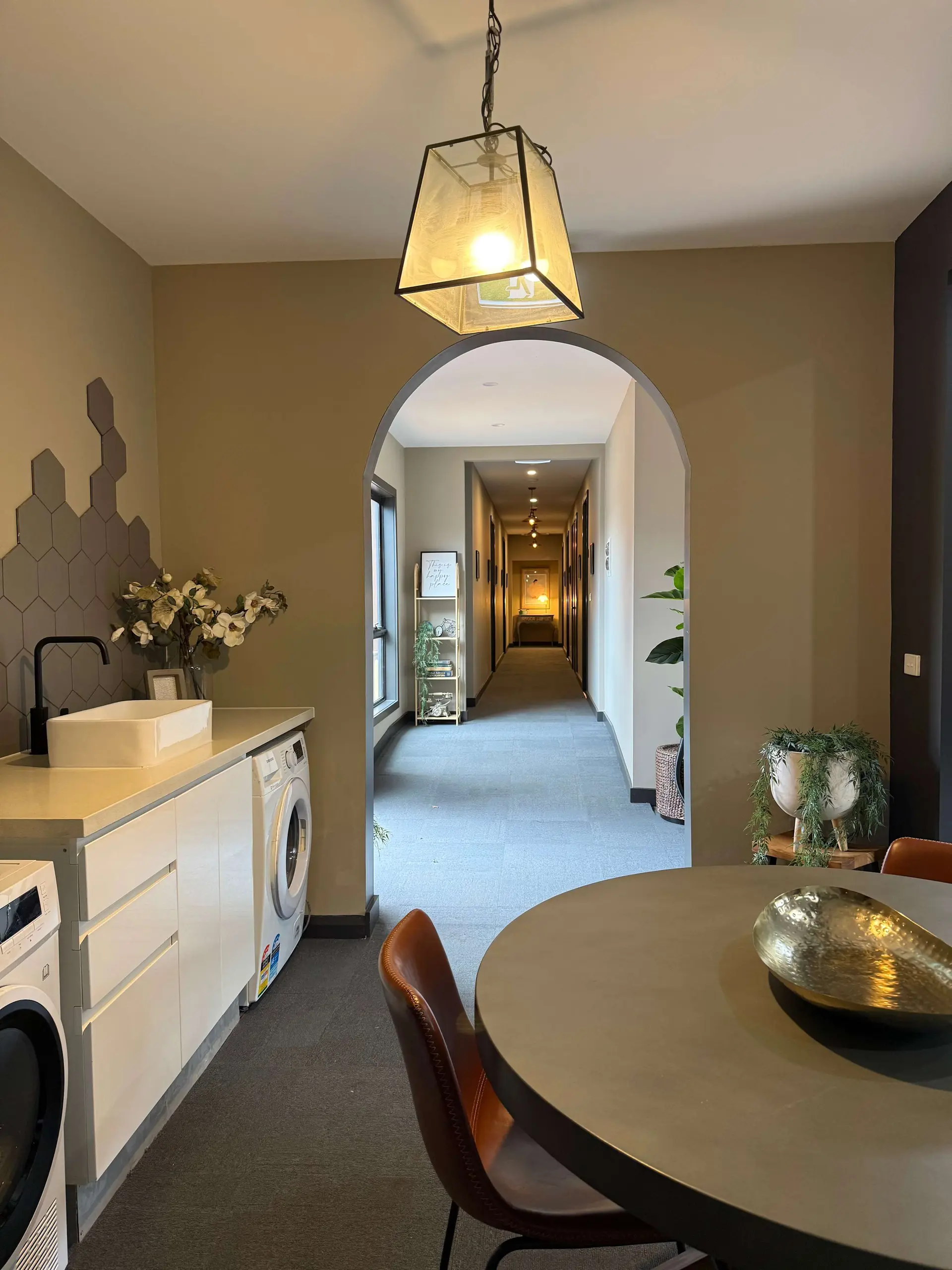 Interior view of a hallway with laundry area and dining table.