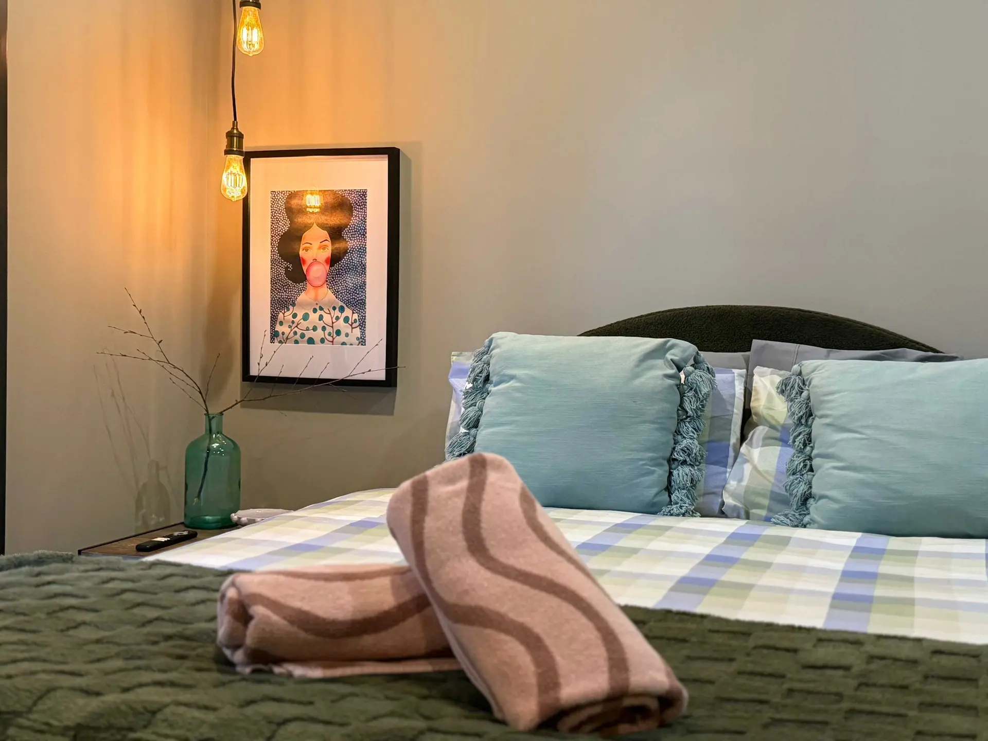 A bed with pillows and a painting.