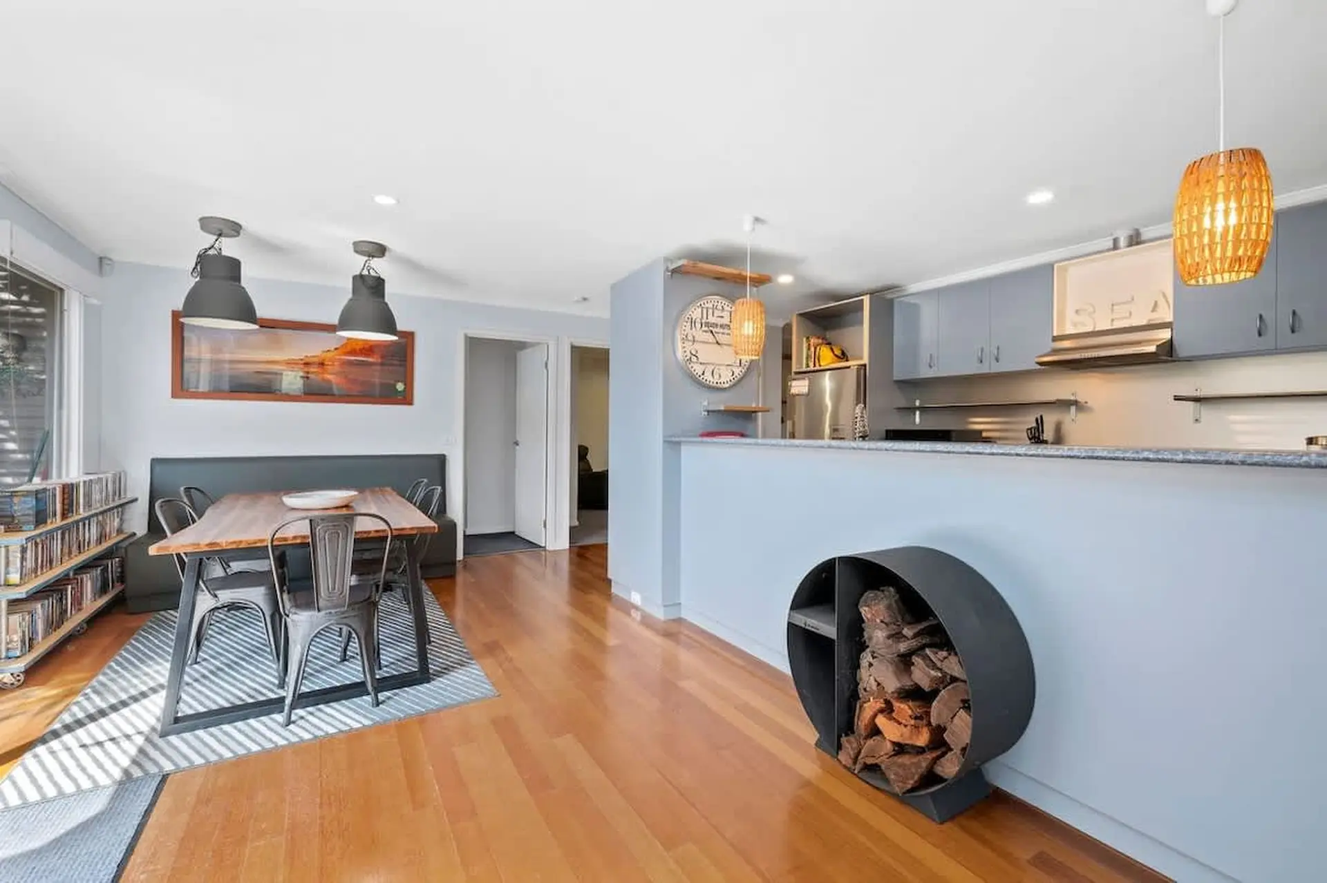 Interior of a dining area and kitchen with a wood burner.