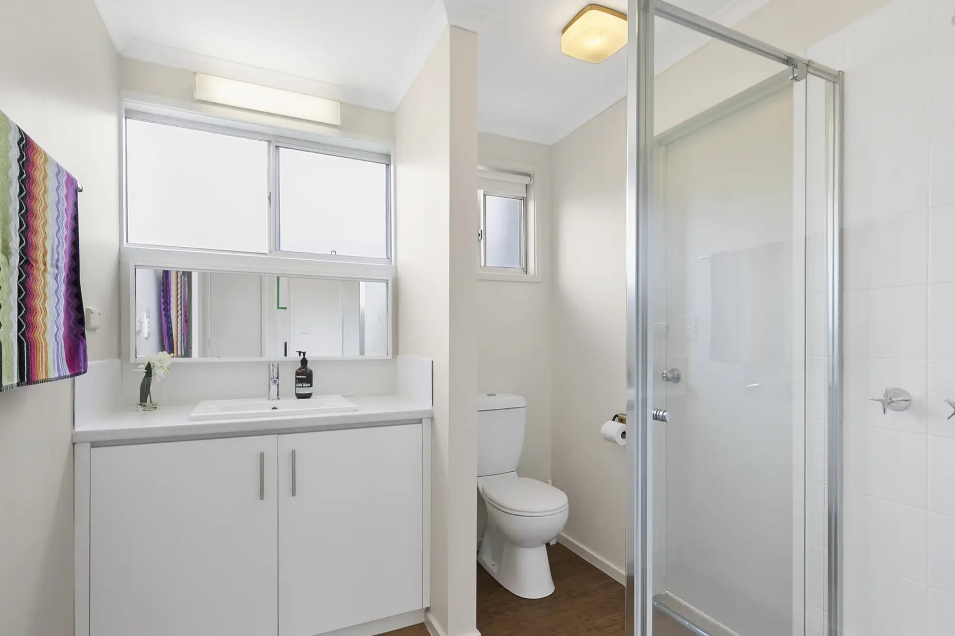 A modern bathroom with a toilet, sink, and shower.
