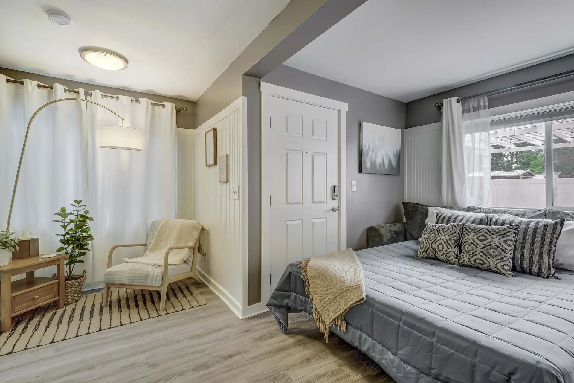 Bedroom with a bed, chair, and door.
