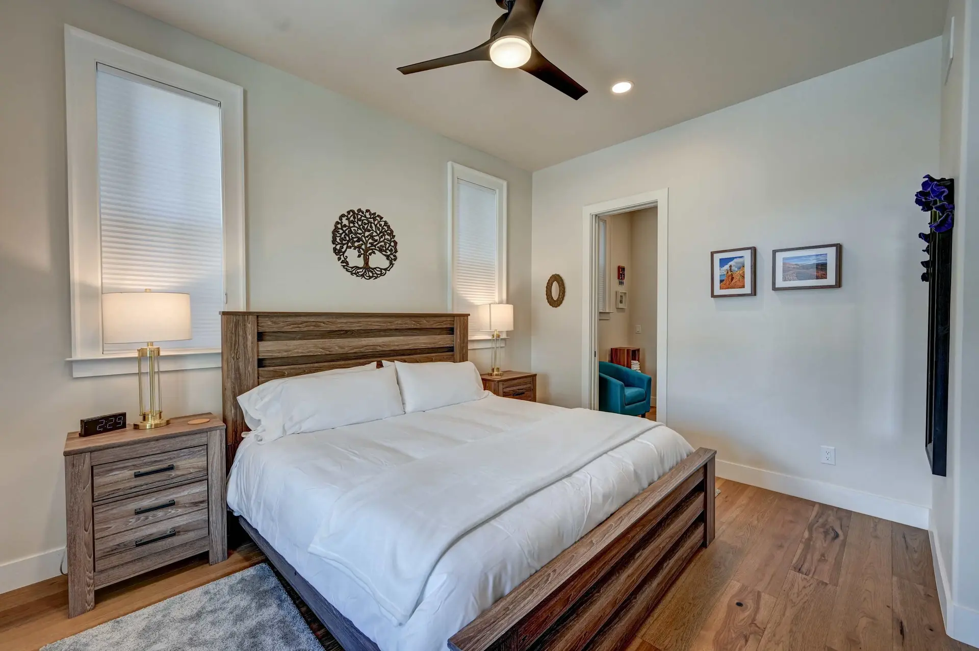 Bedroom with a king-size bed, wooden furniture, and wall art.