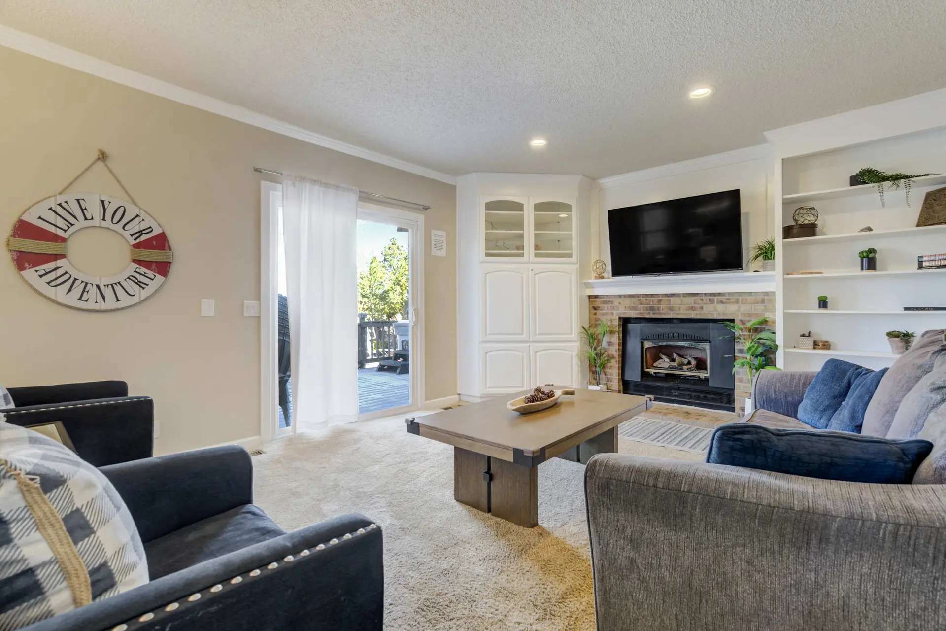 A bright living room with a fireplace, TV, and seating.