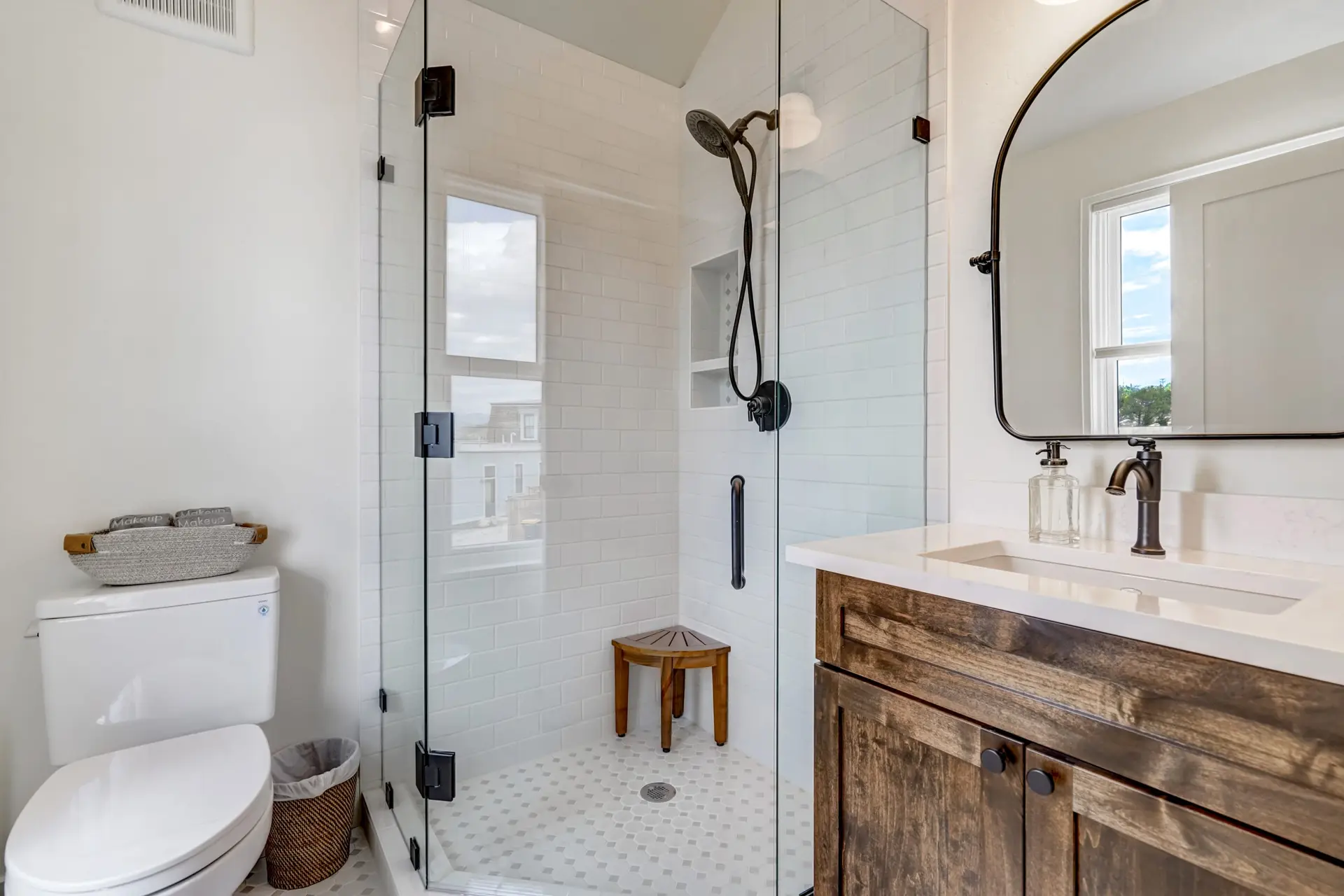 Modern bathroom with a glass-enclosed shower, vanity, and toilet.
