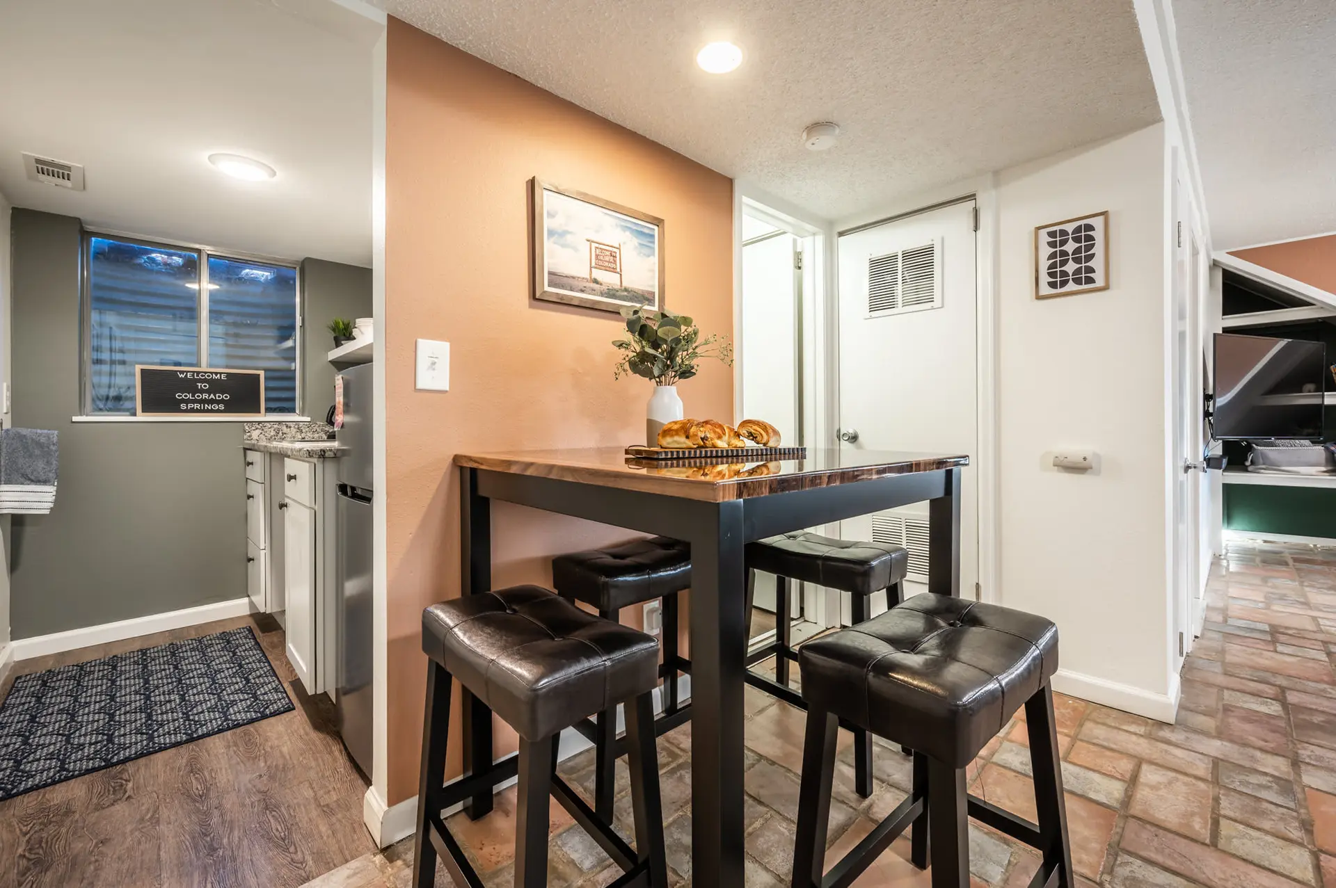 A modern kitchen island with four stools and bread is captured in this photo.