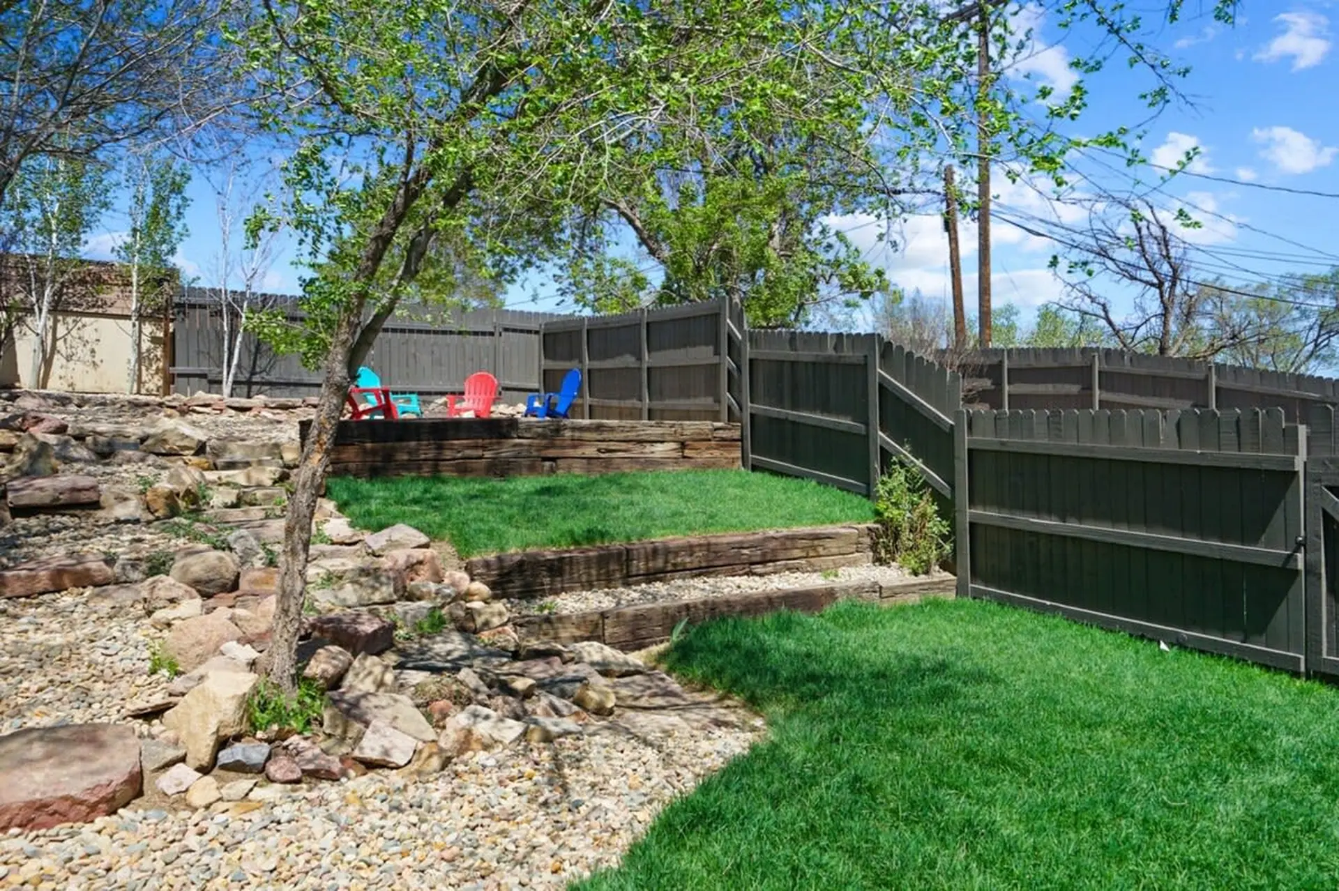 A backyard with a rock garden and tiered grass levels.