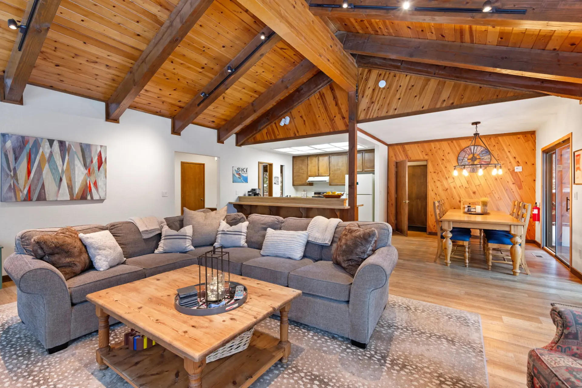 Cozy living room with sectional sofa, wooden beams, and ski decor.
