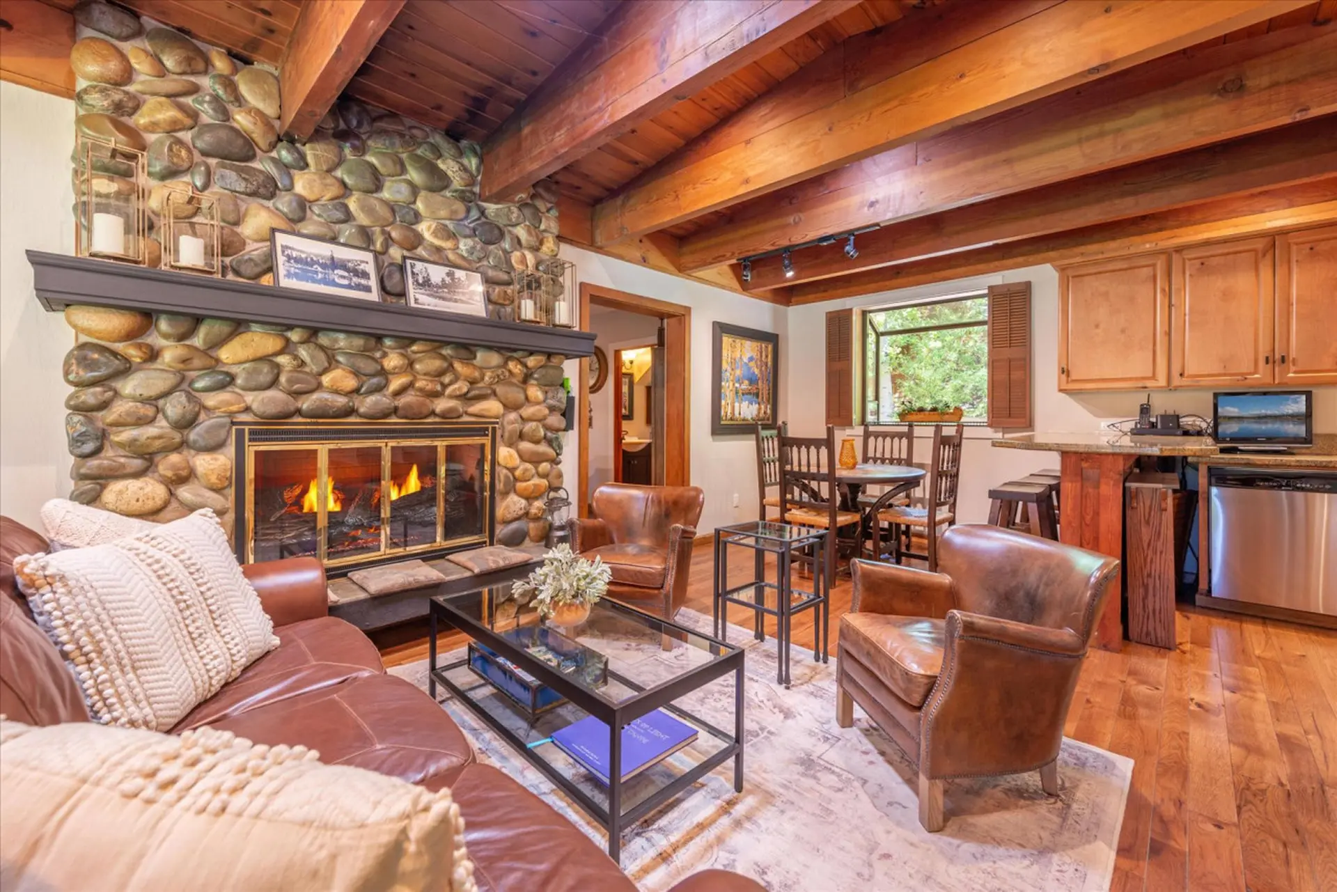 Cozy living room with stone fireplace, leather furniture, and wood accents.