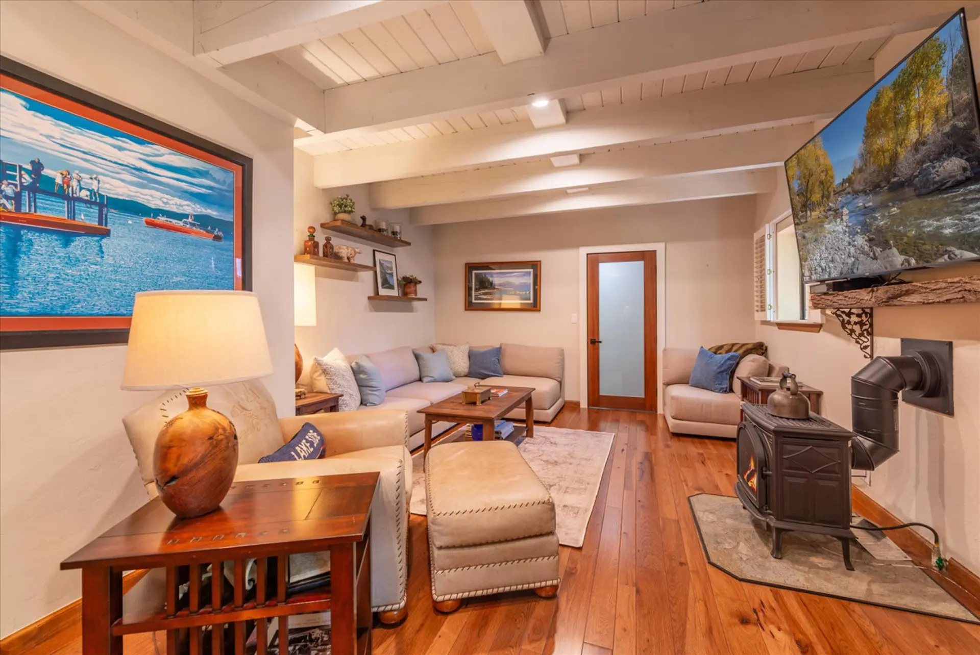 Living room with a sectional sofa, ottoman, wood-burning stove, and TV.