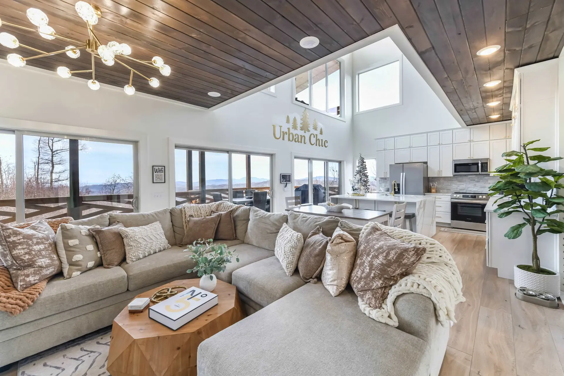 A large sectional couch in a modern living room with a wooden ceiling and a view of mountains.