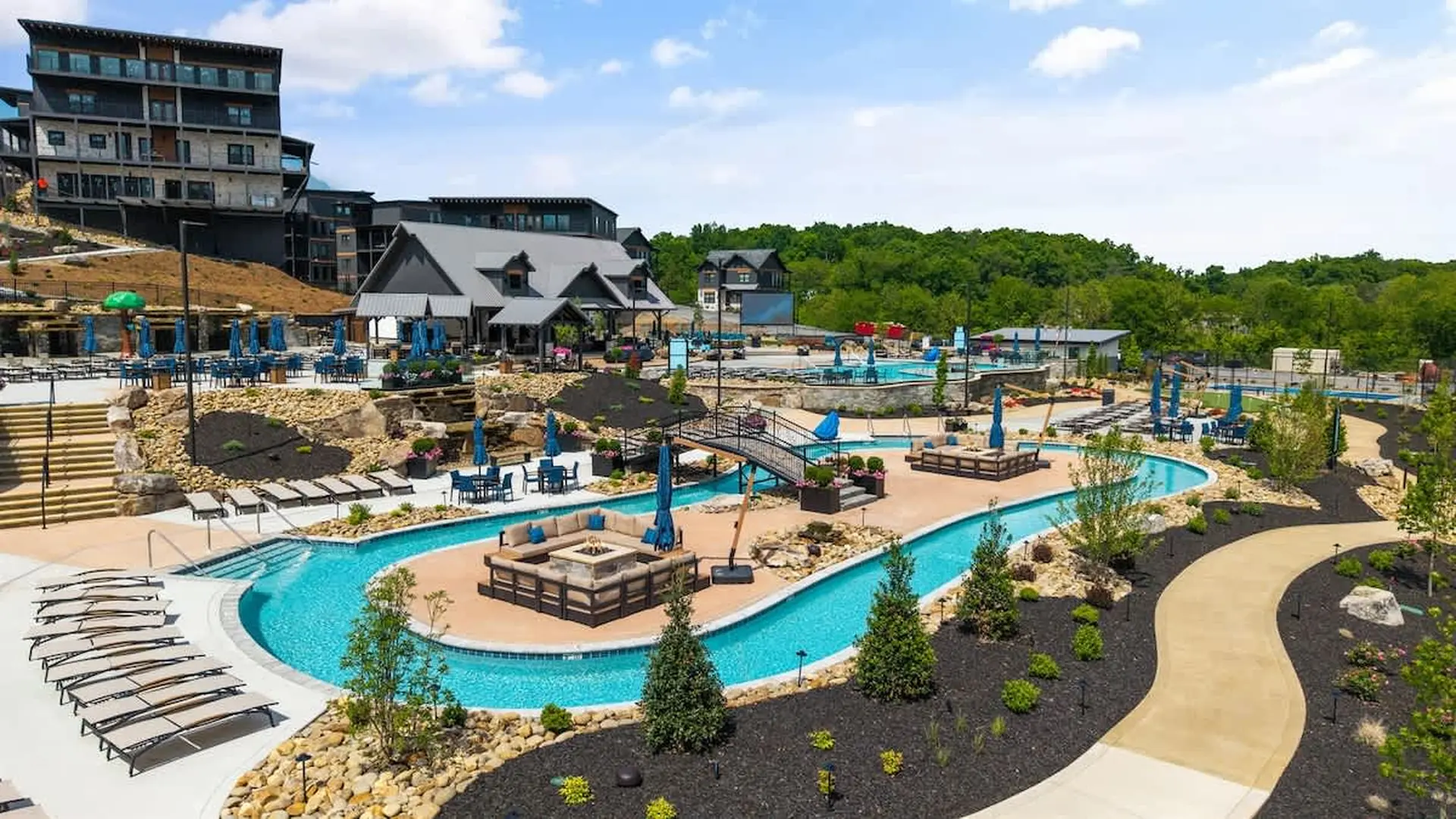 Resort lazy river and pools with lounge chairs and umbrellas.