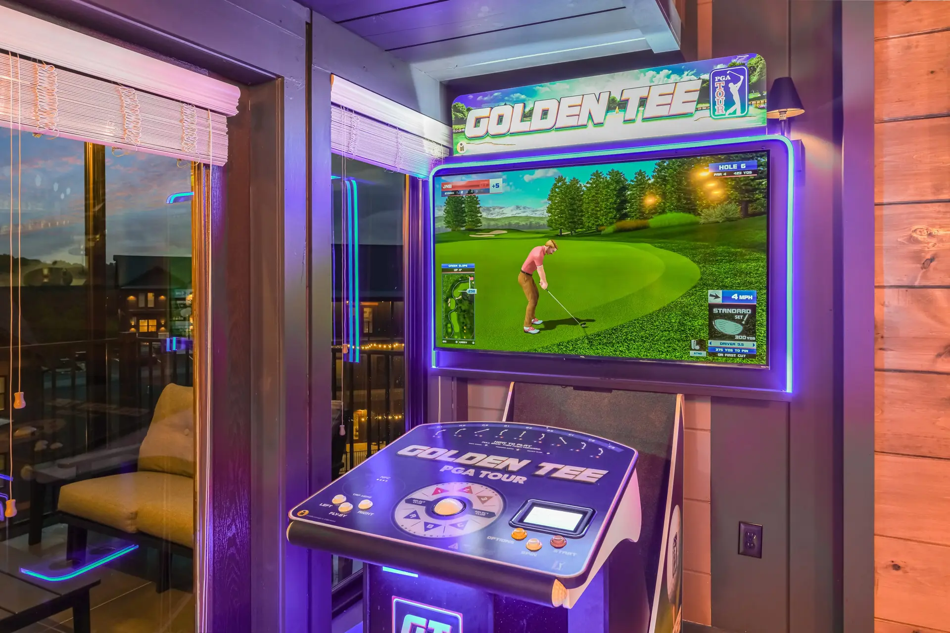 A Golden Tee PGA Tour golf arcade game glows with purple and green lights.