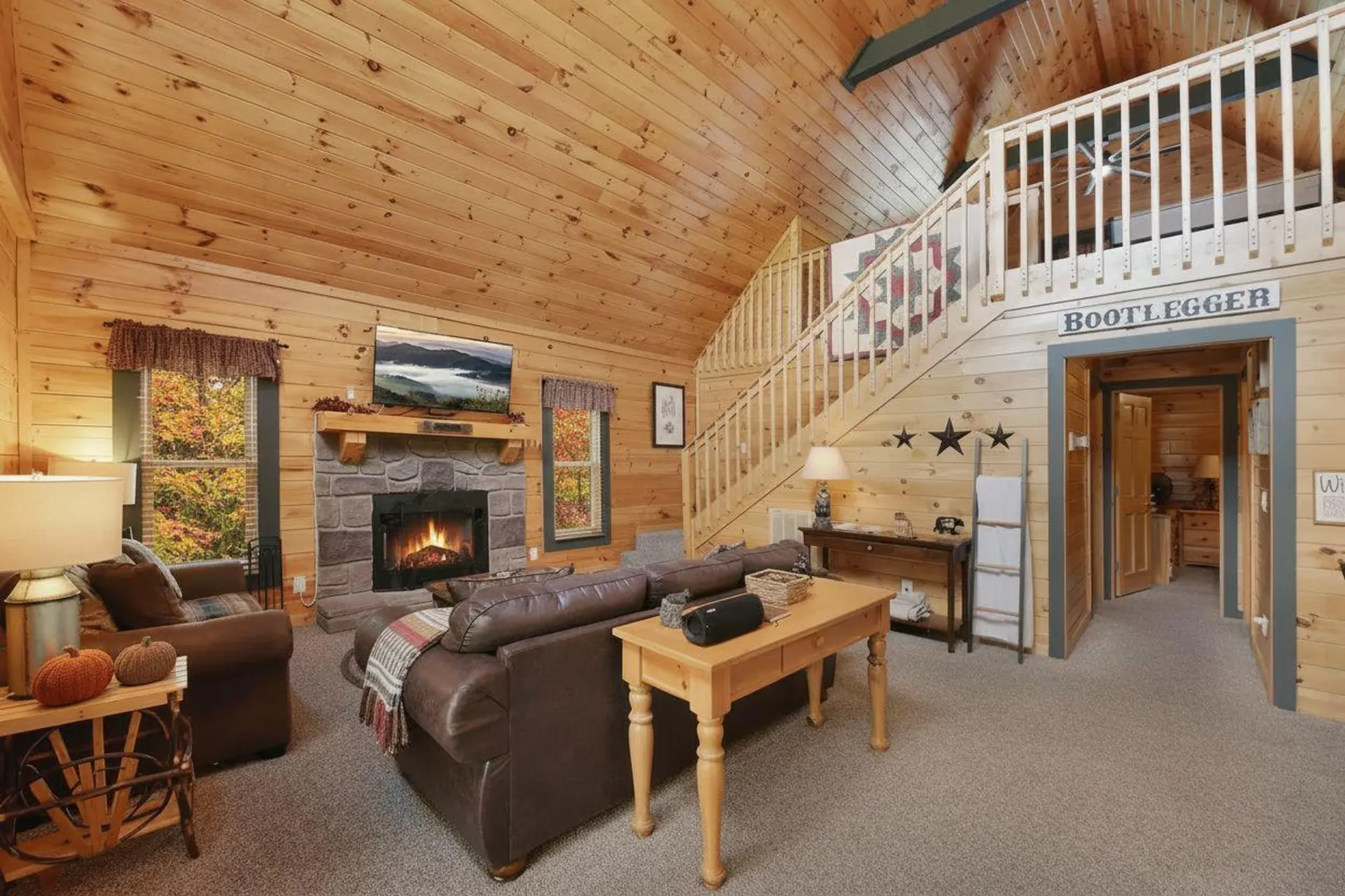 Living room with fireplace, sofa, and staircase leading to loft.