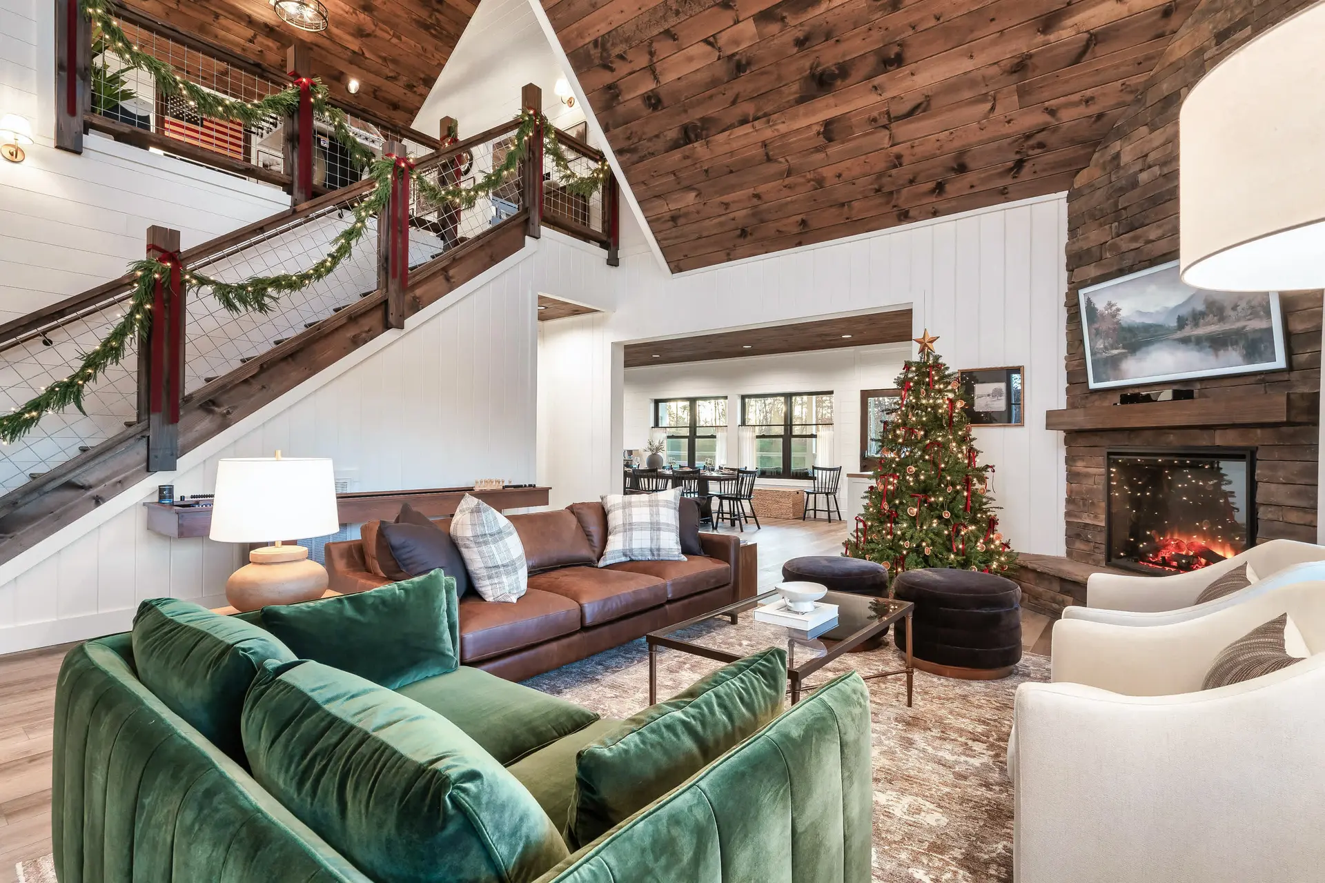 Cozy living room decorated for Christmas with a fireplace, tree, and warm lighting.