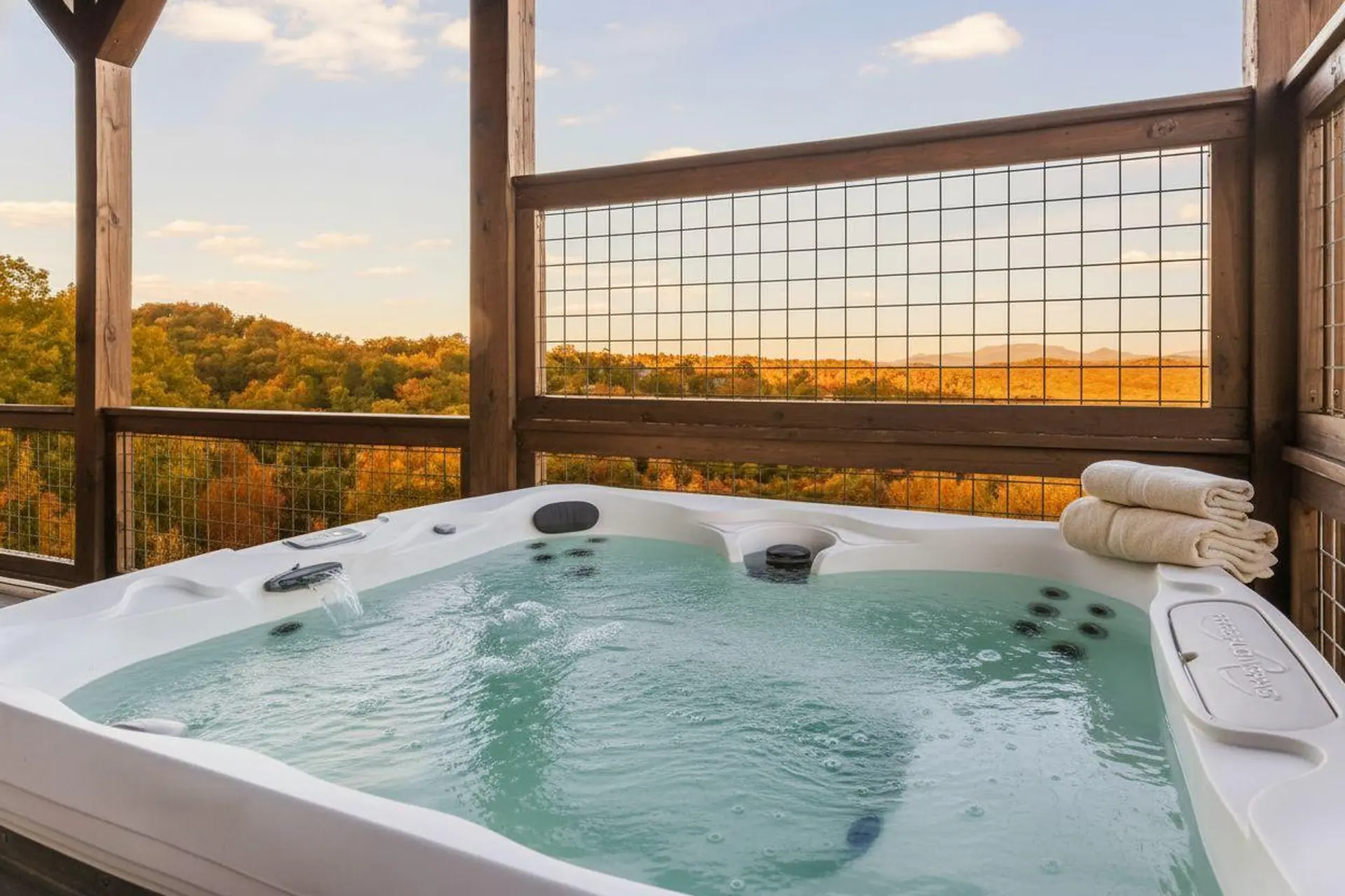 A hot tub on a deck overlooks a colorful autumn forest landscape.
