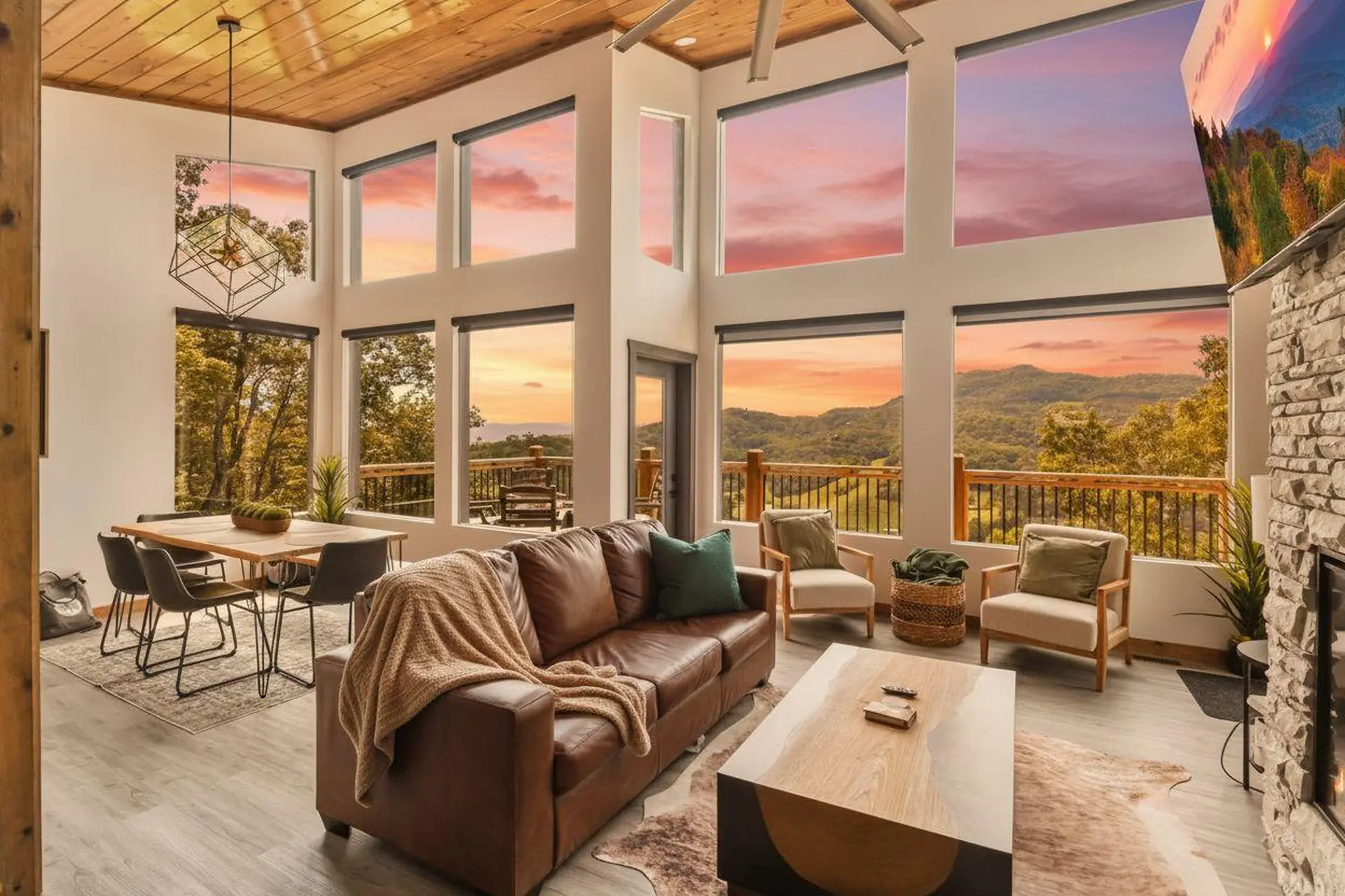 Living room with large windows overlooking mountains at sunset.
