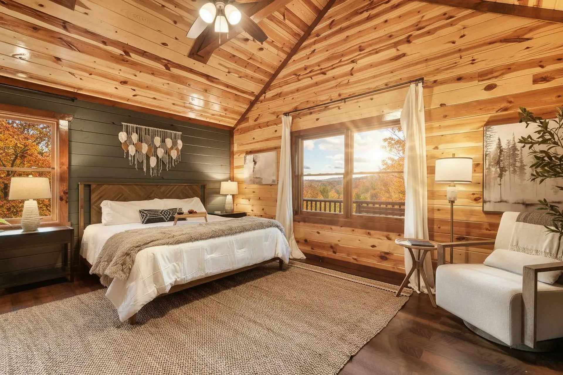 Cozy bedroom with wood walls and a view of autumn foliage.