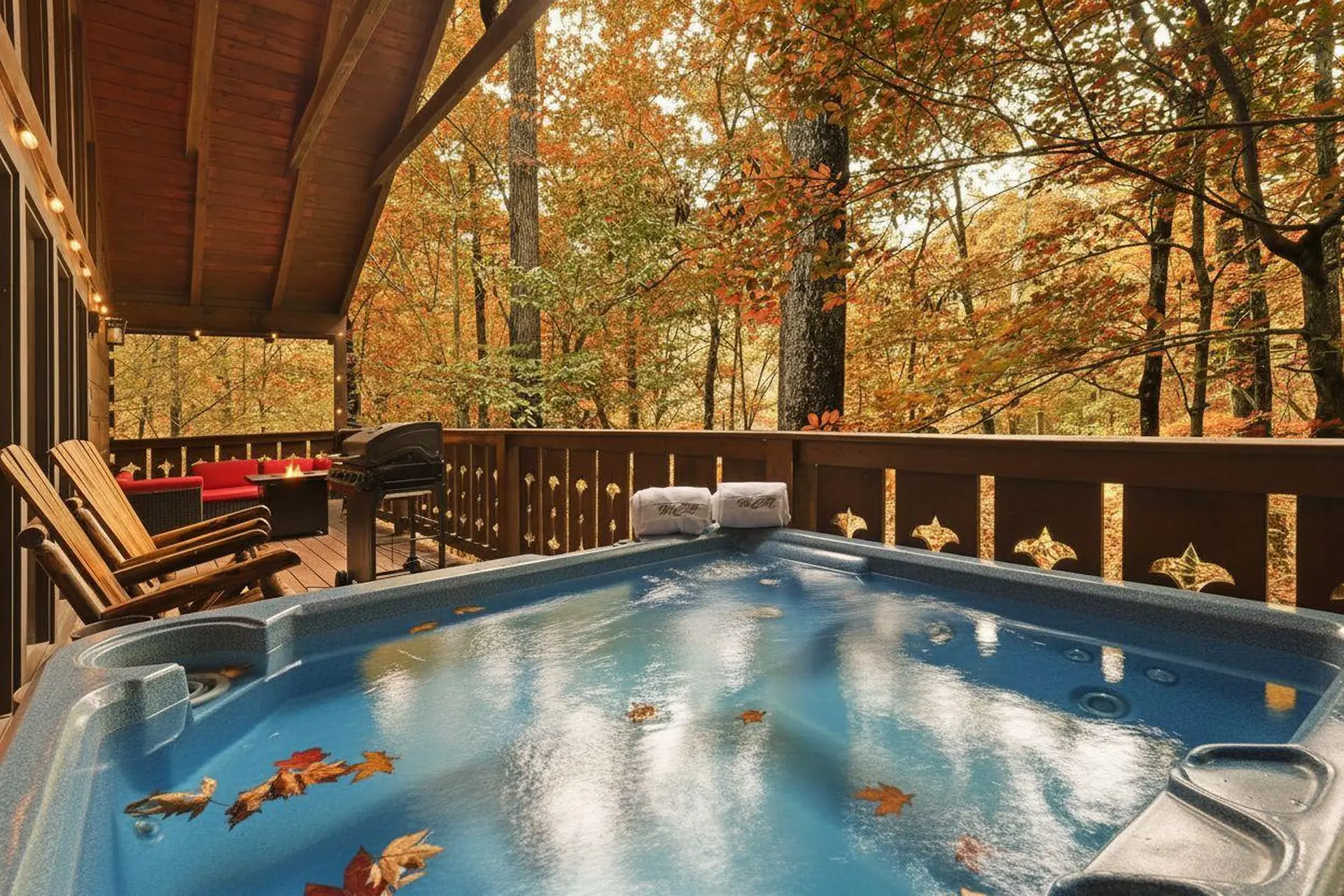 Outdoor hot tub with autumn leaves and a forest view.