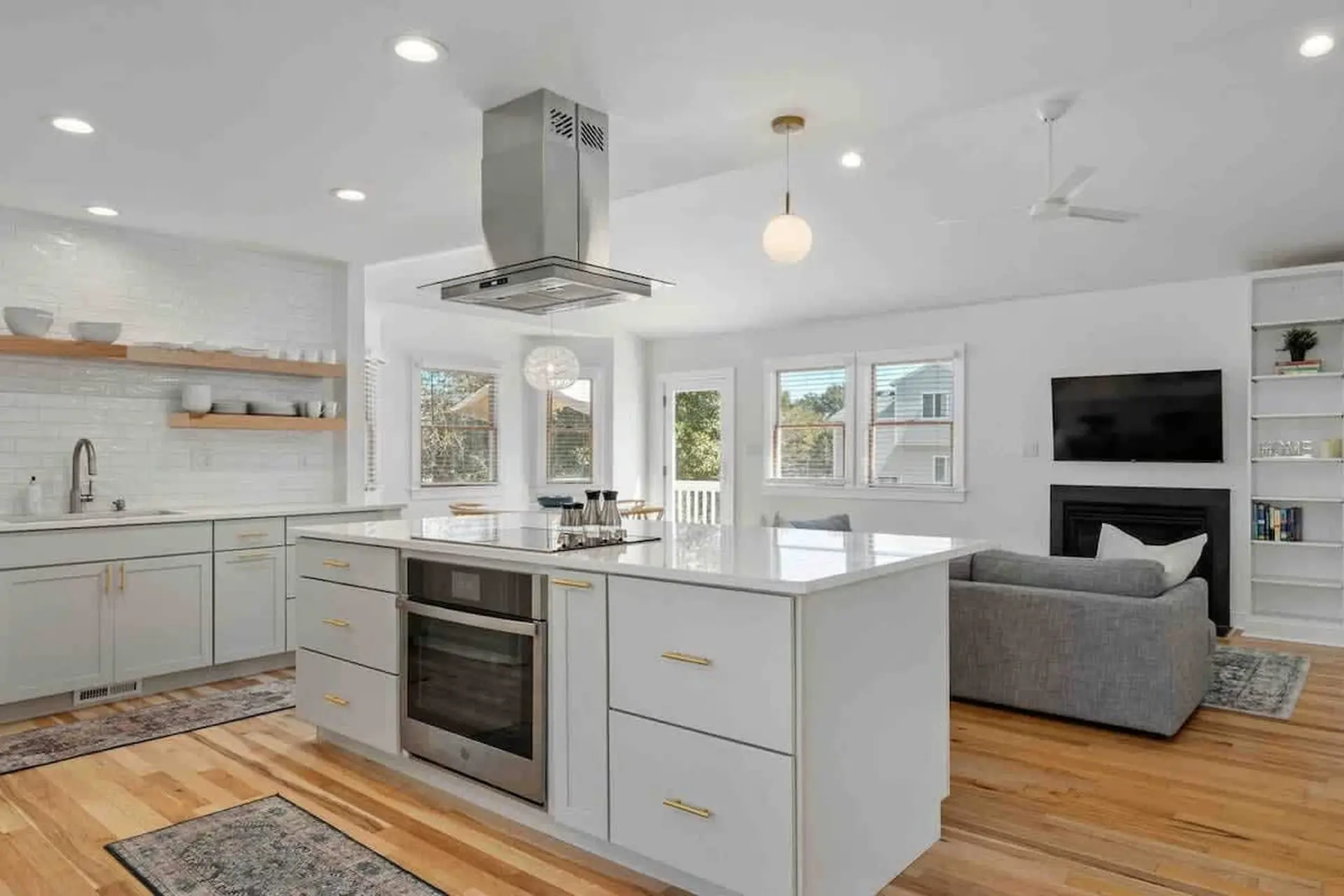 A modern kitchen island with an oven is the centerpiece of this open-concept living space.