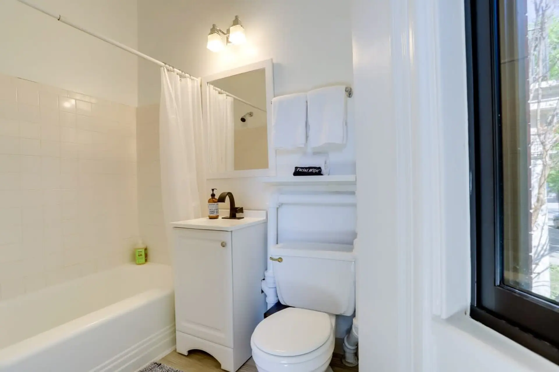 A clean white bathroom features a bathtub, sink, and toilet.