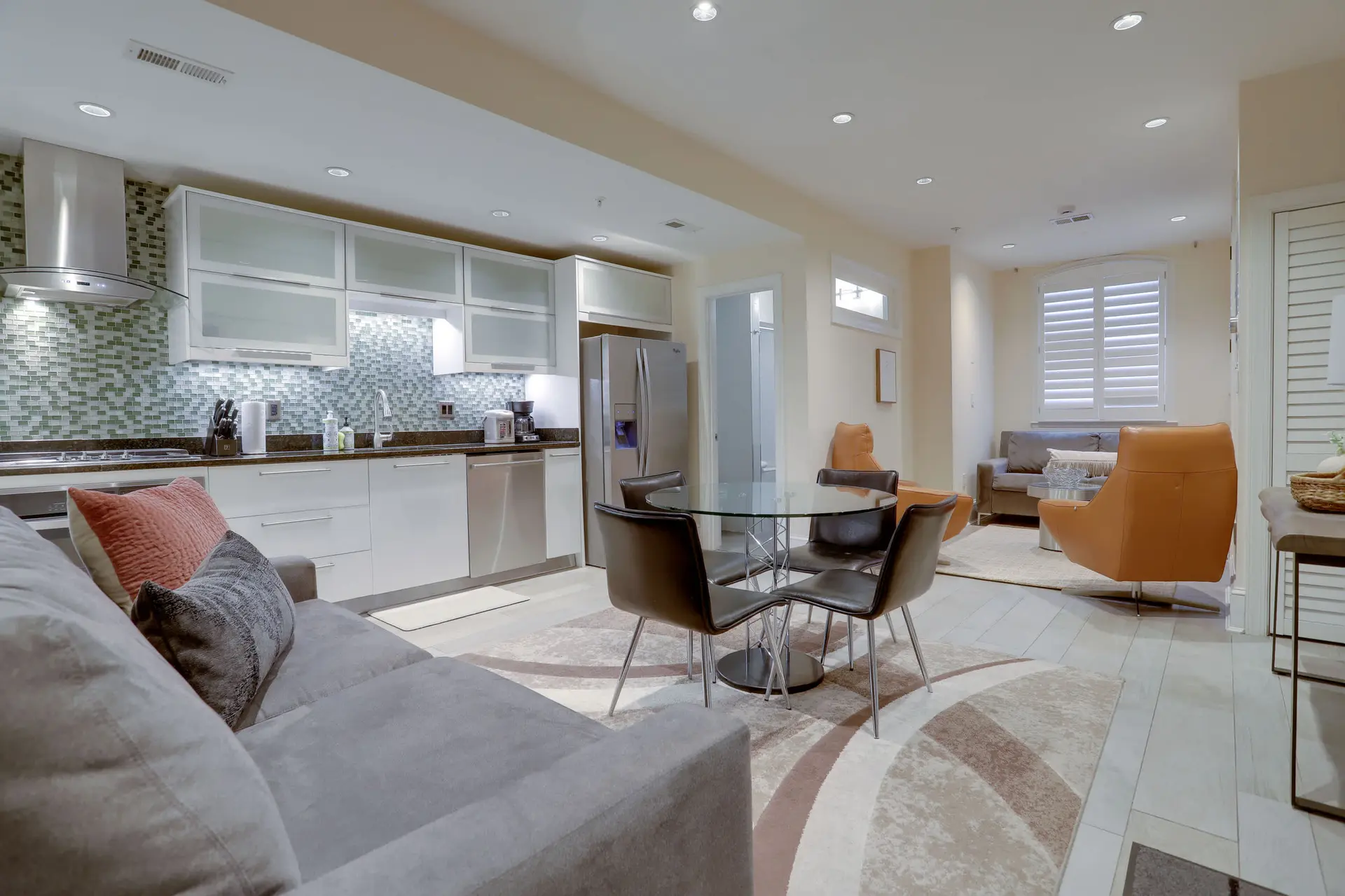 A modern open-plan living space with a sleek kitchen, dining area, and living room.