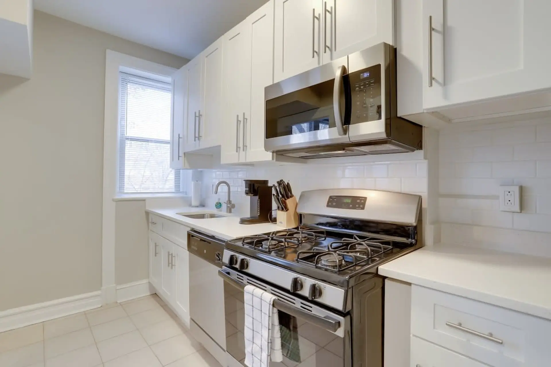 A stainless steel stove with a microwave above in a clean, modern kitchen.