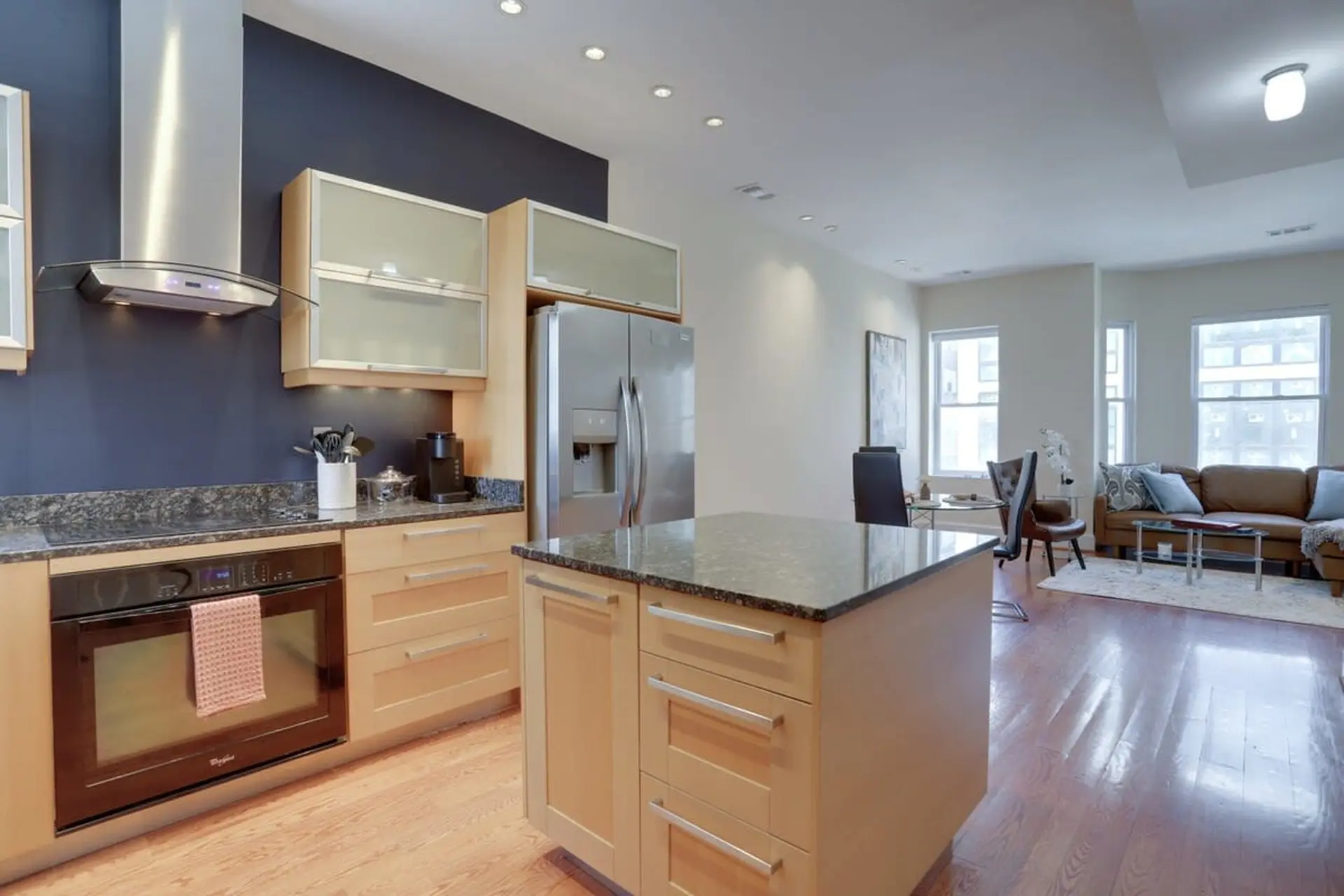 A modern kitchen with stainless steel appliances, granite countertops, and a breakfast island.